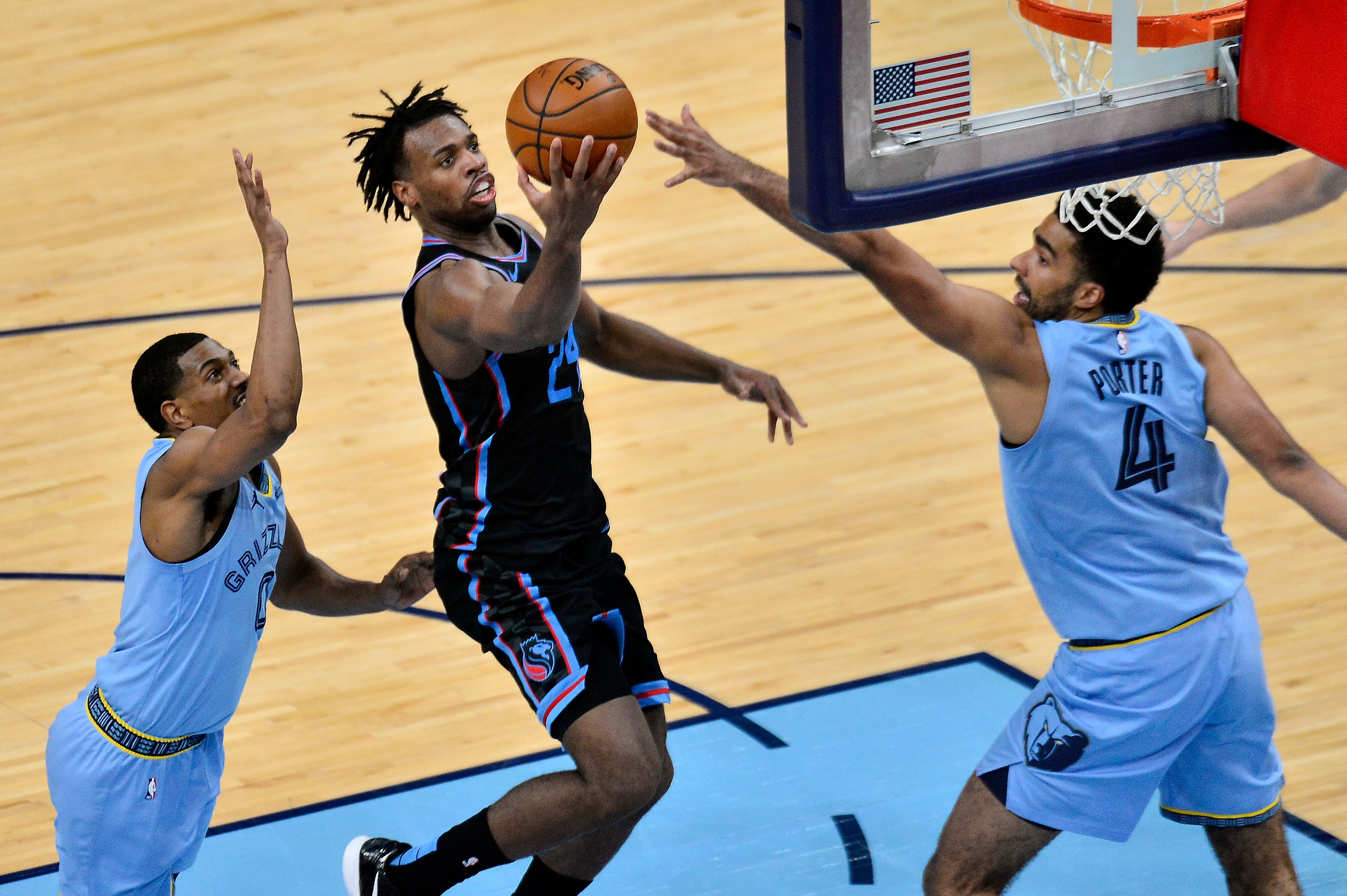 Sacramento Kings guard Buddy Hield (24) shoots between Memphis Grizzlies forward Jontay Porter (4) and guard De'Anthony Melton (0) in the second half of an NBA basketball game Friday, May 14, 2021, in Memphis, Tenn. (AP Photo/Brandon Dill)