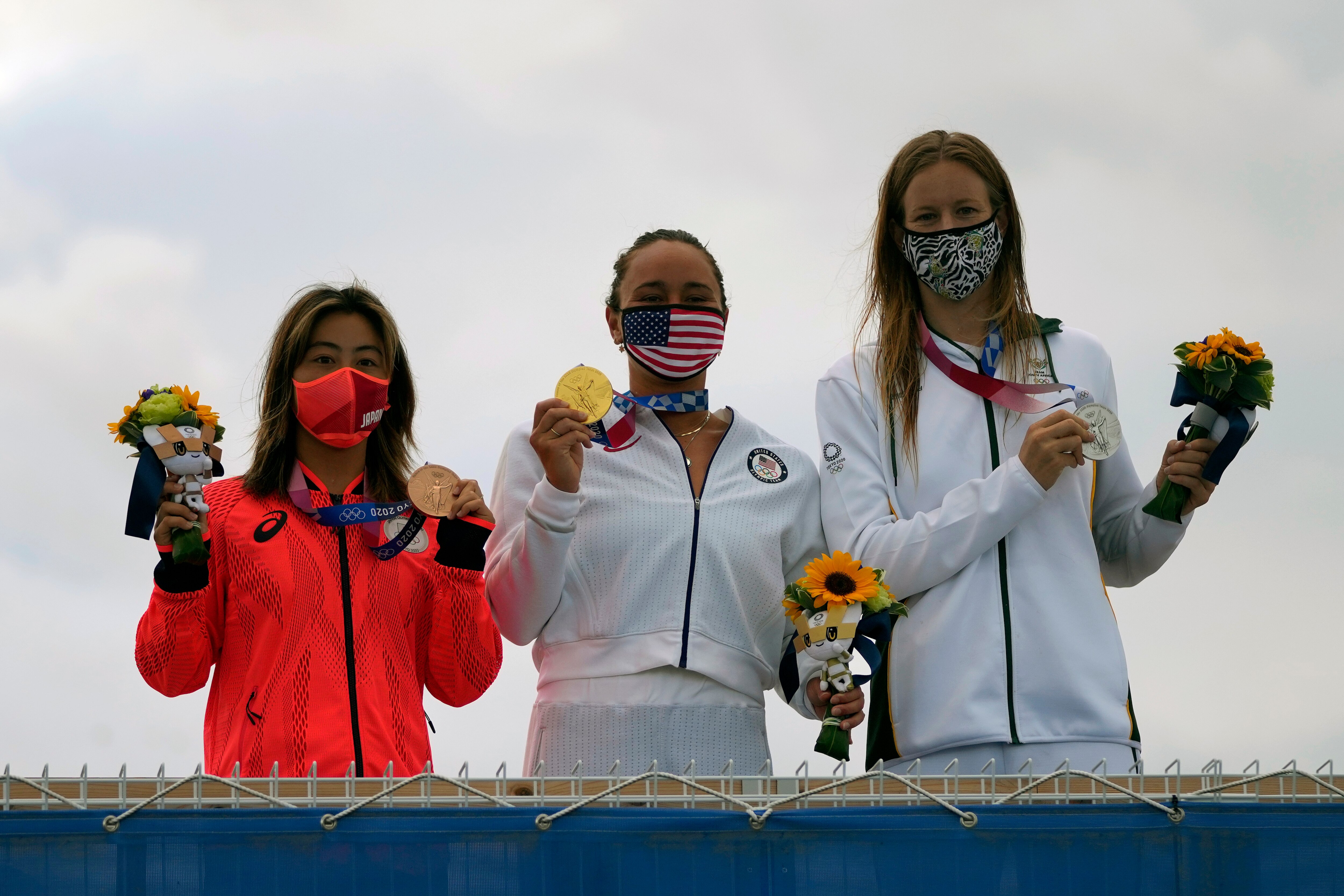 Carissa Moore, of the United States, holds the gold medal, South Africa's Bianca Buitendag holds the silver medal and Japan's Amuro Tsuzuki holds the bronze medal in the women's surfing competition at the 2020 Summer Olympics, Tuesday, July 27, 2021, at Tsurigasaki beach in Ichinomiya, Japan. (AP Photo/Francisco Seco)