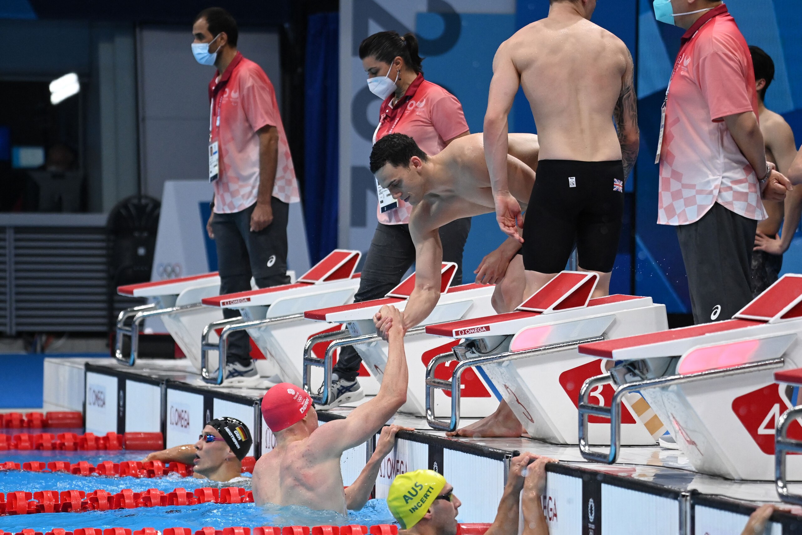 Britain's Tom Dean (C, in water) celebrates with teammate James Guy after winning a heat for the men's 4x200m freestyle relay swimming event during the Tokyo 2020 Olympic Games at the Tokyo Aquatics Centre in Tokyo on July 27, 2021. (Photo by Jonathan NACKSTRAND / AFP) (Photo by JONATHAN NACKSTRAND/AFP via Getty Images)