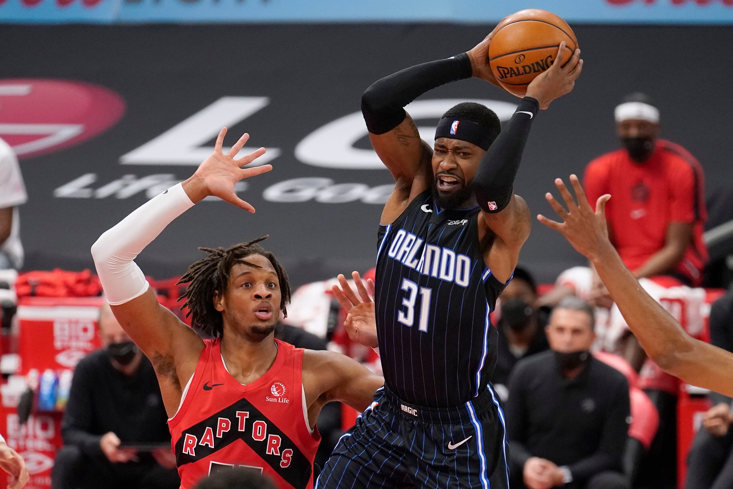 Orlando Magic guard Terrence Ross (31) fires a pass over Toronto Raptors forward Freddie Gillespie (55) during the first half of an NBA basketball game Friday, April 16, 2021, in Tampa, Fla. (AP Photo/Chris O'Meara)