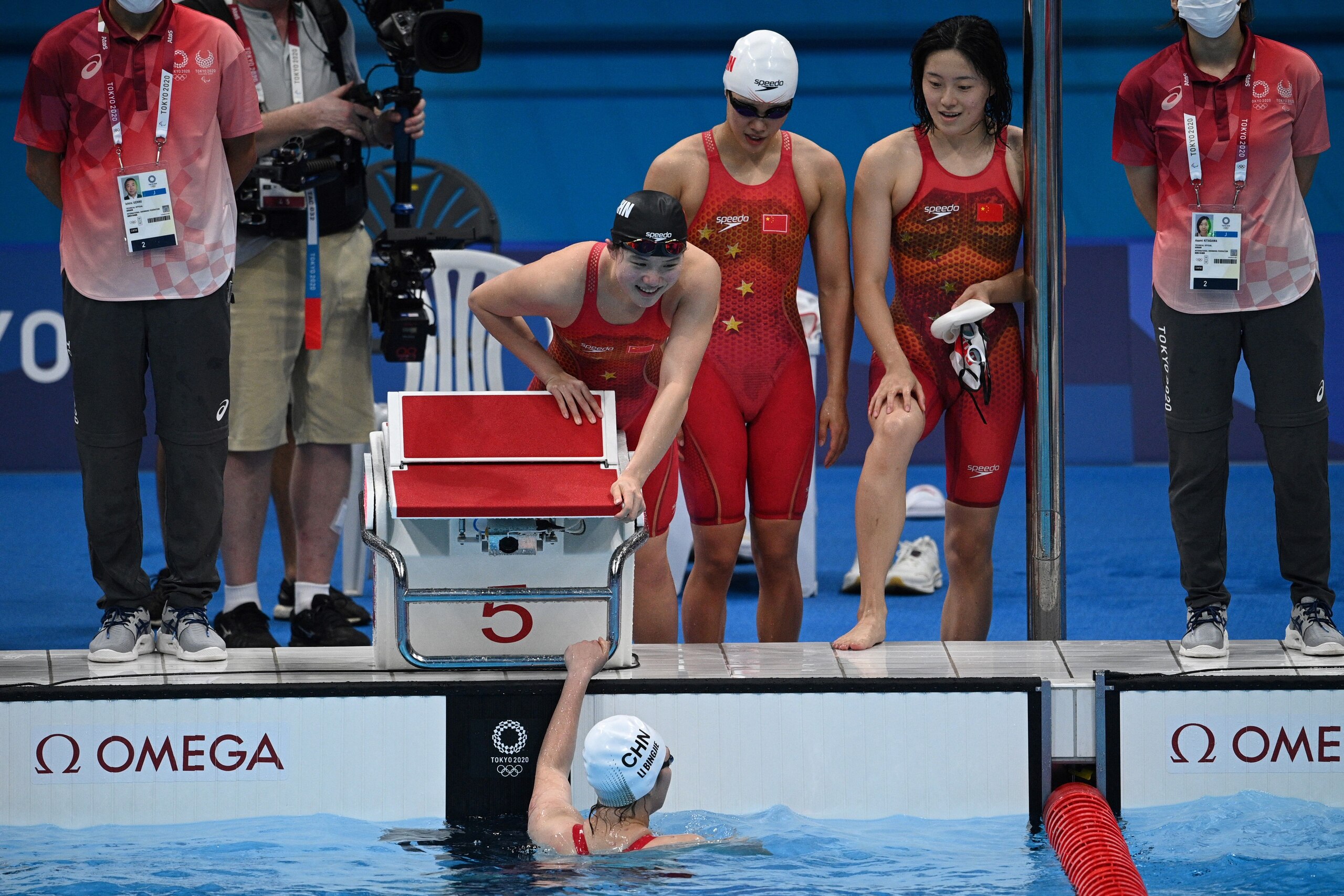 China's Li Bingjie (bottom) celebrates with China's Tang Muhan, China's Zhang Yufei, and Dong Jie after coming second in a heat for the women's 4x200m freestyle relay swimming event during the Tokyo 2020 Olympic Games at the Tokyo Aquatics Centre in Tokyo on July 28, 2021. (Photo by Oli SCARFF / AFP) (Photo by OLI SCARFF/AFP via Getty Images)