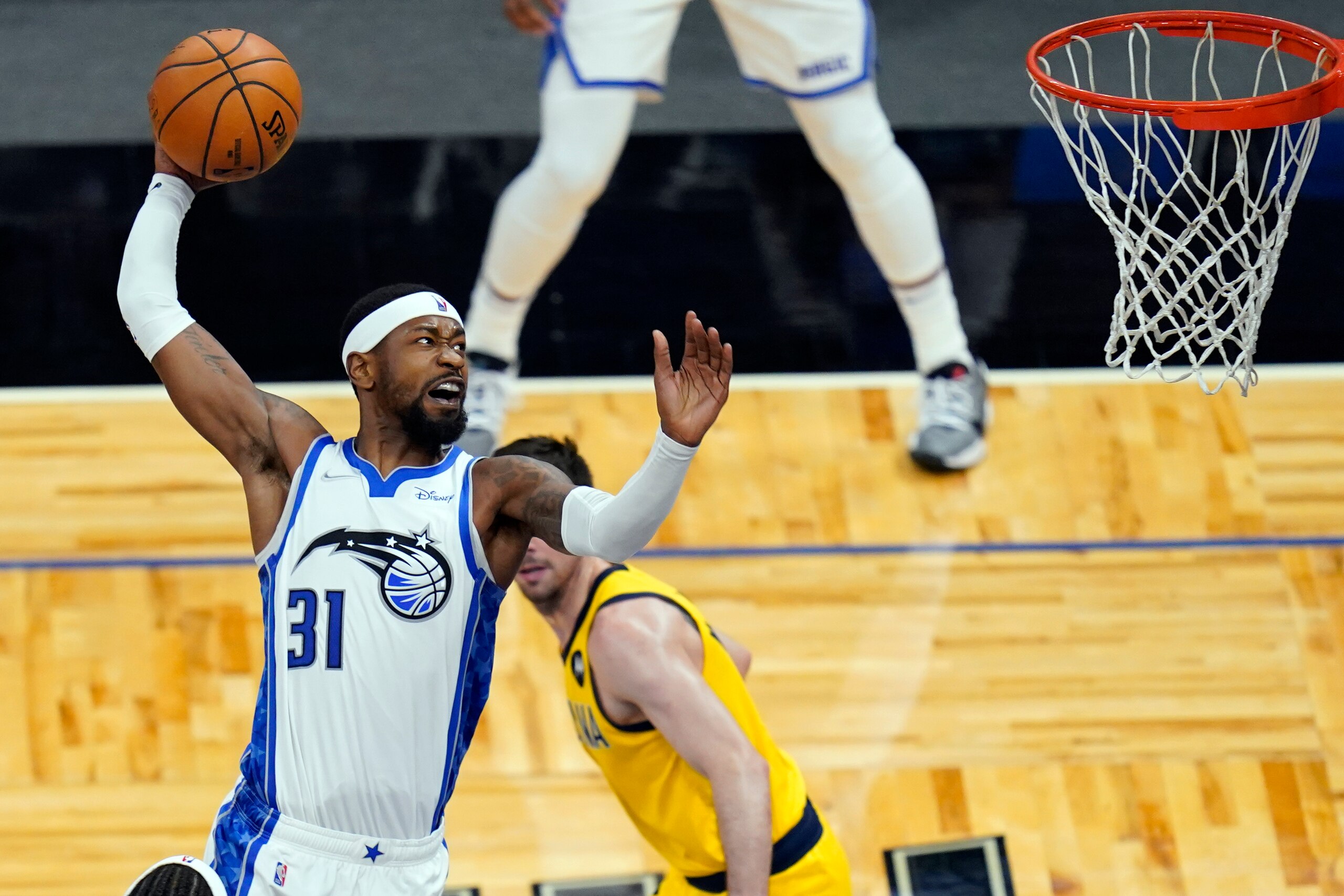 Orlando Magic guard Terrence Ross (31) goes up past Indiana Pacers guard T.J. McConnell, right, for a dunk during the second half of an NBA basketball game, Friday, April 9, 2021, in Orlando, Fla. (AP Photo/John Raoux)