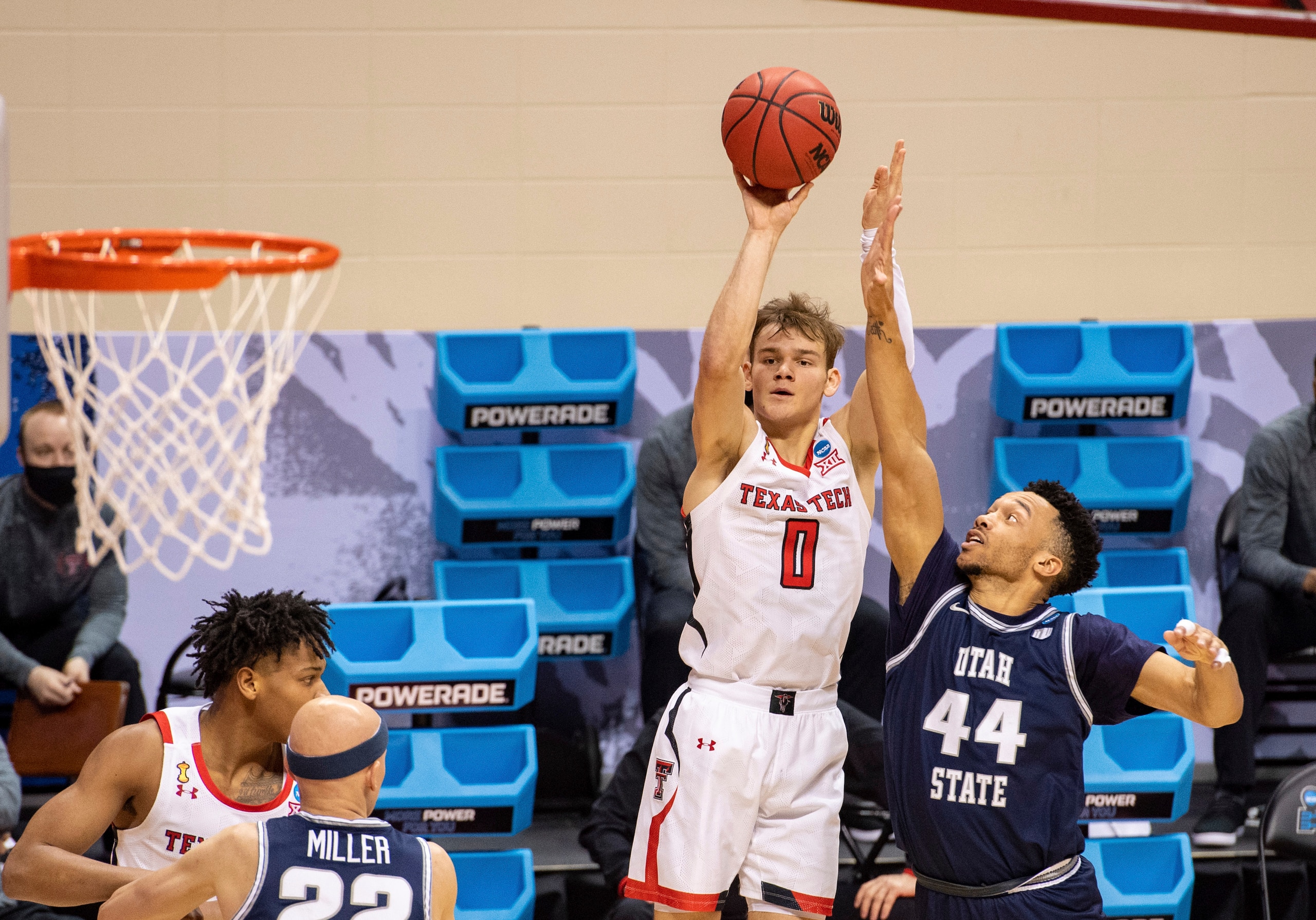 Texas Tech guard Mac McClung (0) shoots a 3-point shot while Utah State guard Marco Anthony (44) defends during the second half of a first round game in the NCAA men's college basketball tournament, Friday, March 19, 2021, at Assembly Hall in Bloomington, Ind. (AP Photo/Doug McSchooler)