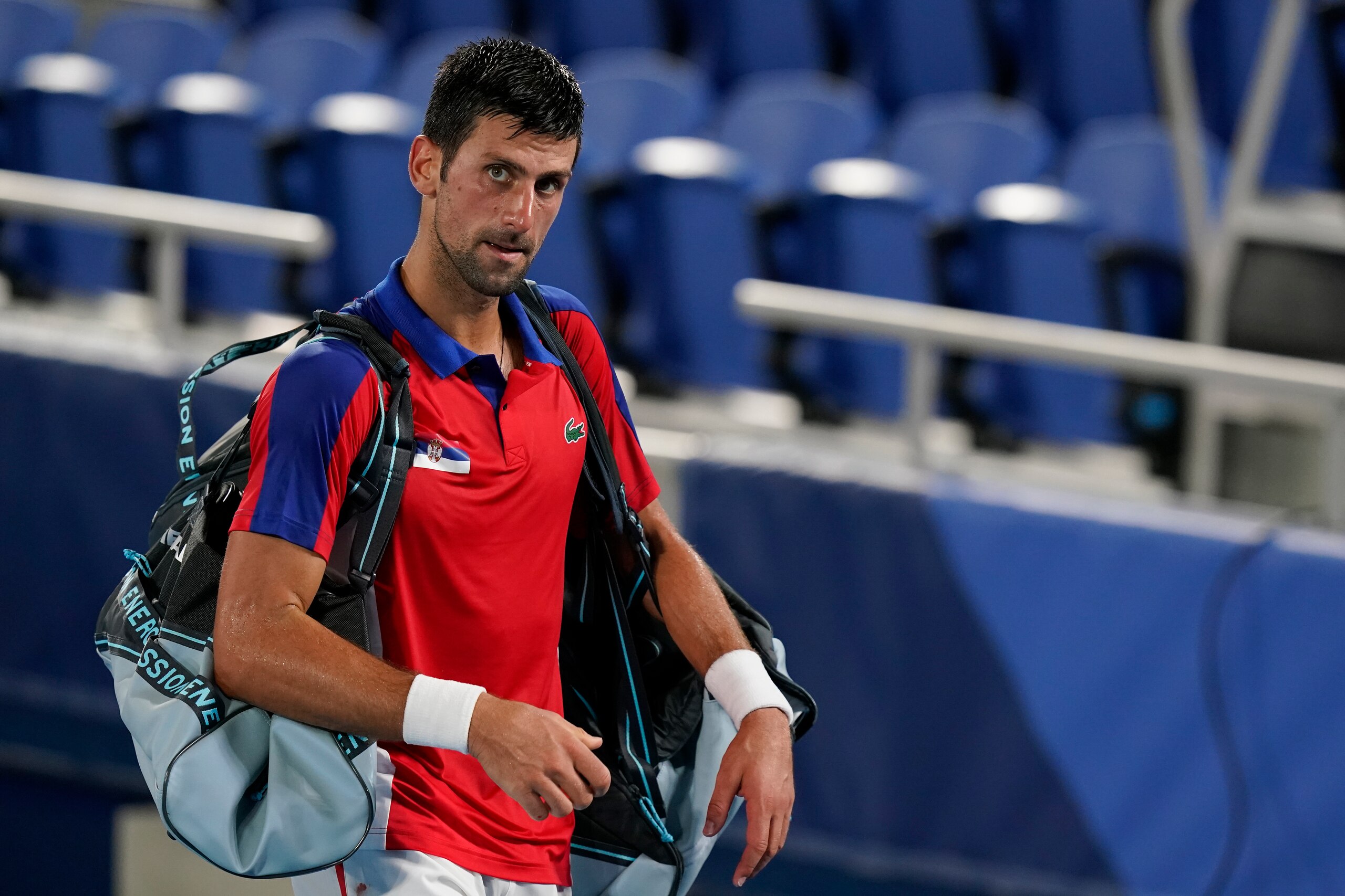 Novak Djokovic, of Serbia, walks off the court after losing a semifinal men's tennis match to Alexander Zverev, of Germany, at the 2020 Summer Olympics, Friday, July 30, 2021, in Tokyo, Japan. (AP Photo/Patrick Semansky)