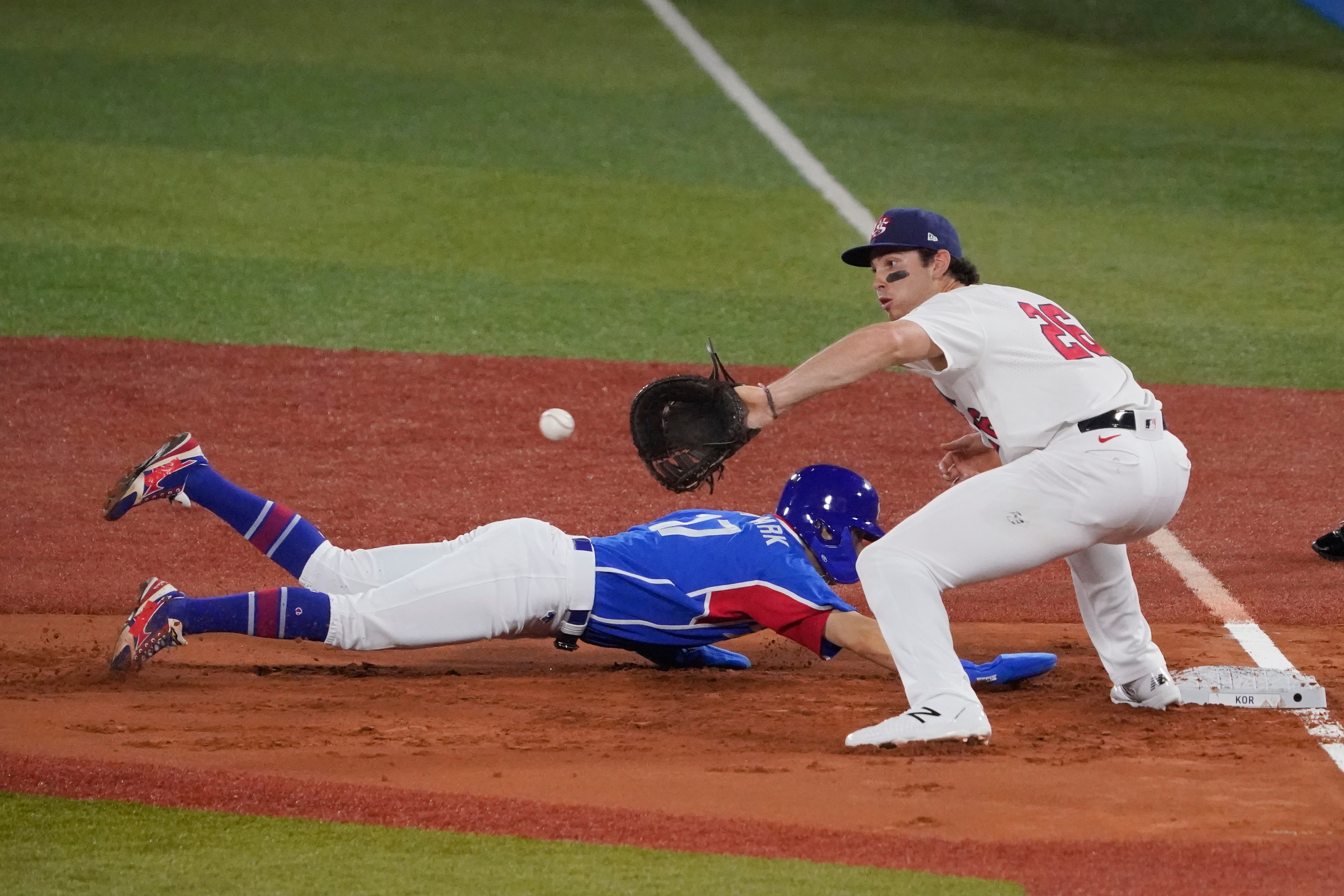 South Korea's Hae Min Park, left, beats the tag by United States' Triston Casas on a pickoff attempt at first during baseball game at the 2020 Summer Olympics, Saturday, July 31, 2021, in Yokohama, Japan. (AP Photo/Sue Ogrocki)