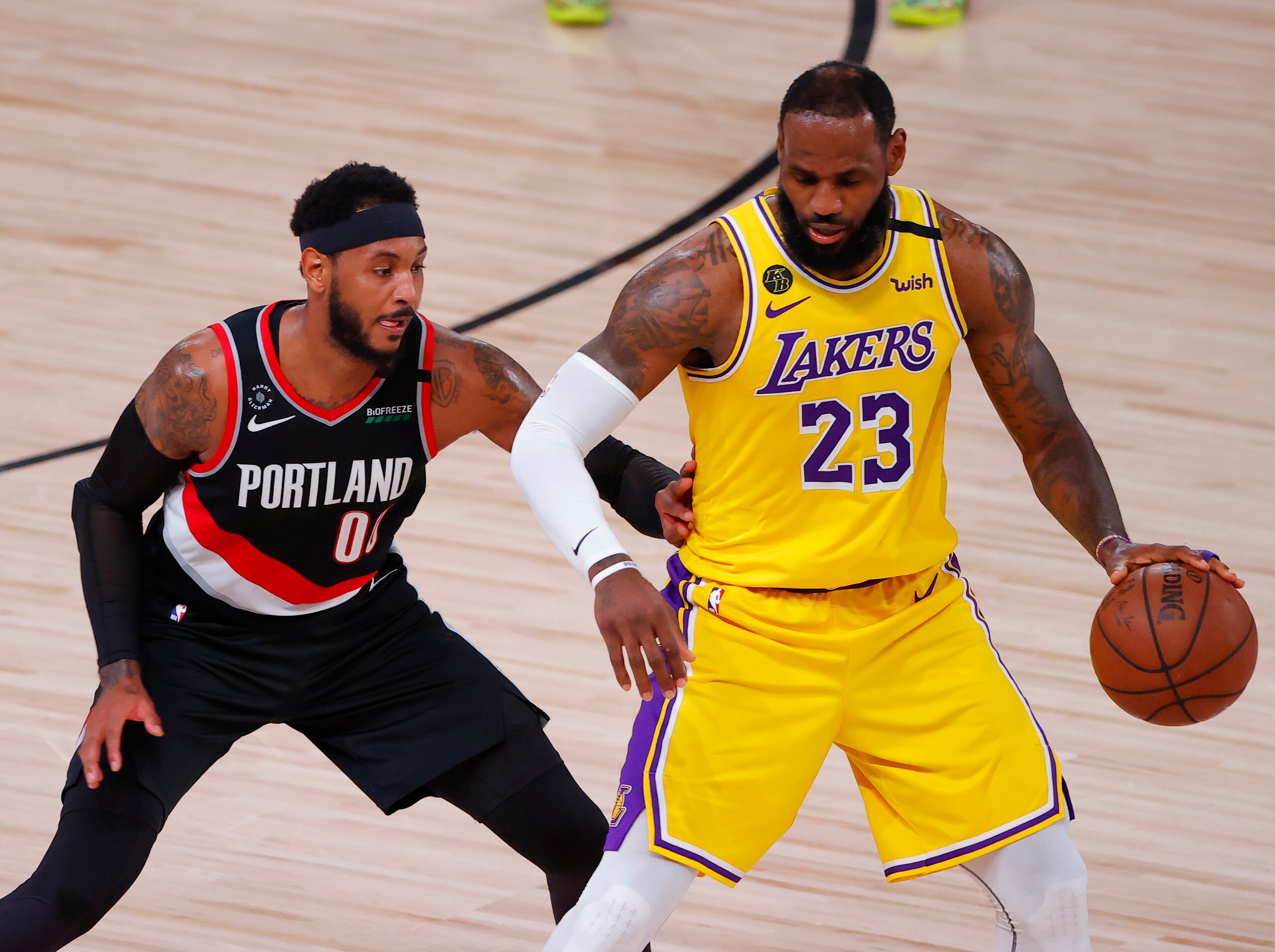 LAKE BUENA VISTA, FLORIDA - AUGUST 29: LeBron James #23 of the Los Angeles Lakers moves the ball against Carmelo Anthony #00 of the Portland Trail Blazers during the second quarter in Game Five of the Western Conference First Round during the 2020 NBA Playoffs at AdventHealth Arena at ESPN Wide World Of Sports Complex on August 29, 2020 in Lake Buena Vista, Florida. NOTE TO USER: User expressly acknowledges and agrees that, by downloading and or using this photograph, User is consenting to the terms and conditions of the Getty Images License Agreement. (Photo by Kevin C. Cox/Getty Images)