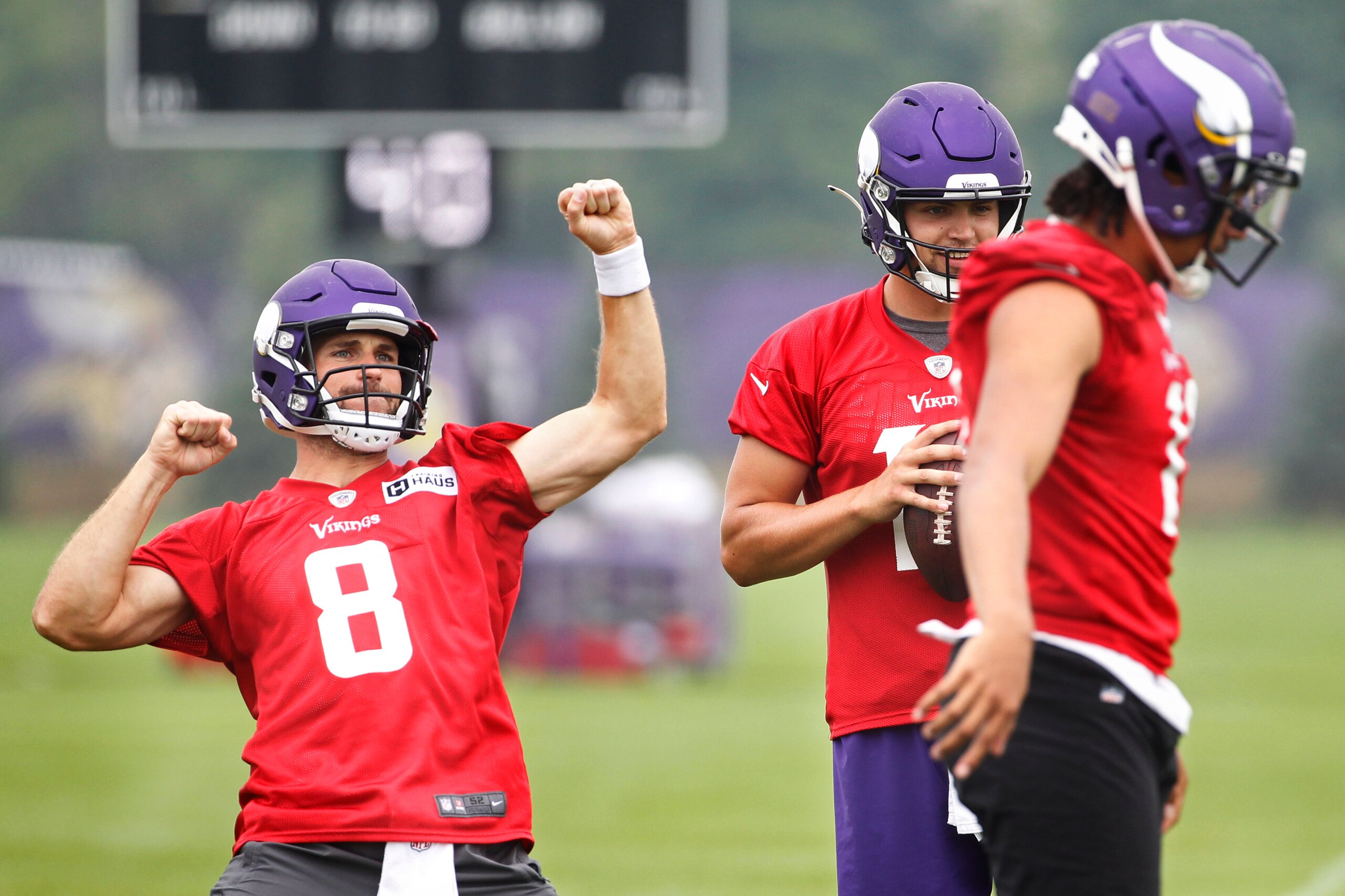 Minnesota Vikings quarterback Kirk Cousins (8) responds to the crowd, next to quarterbacks Nate Stanley (14) and Kellen Mond (11) during NFL football training camp Friday, July 30, 2021, in Eagan, Minn. (AP Photo/Bruce Kluckhohn)