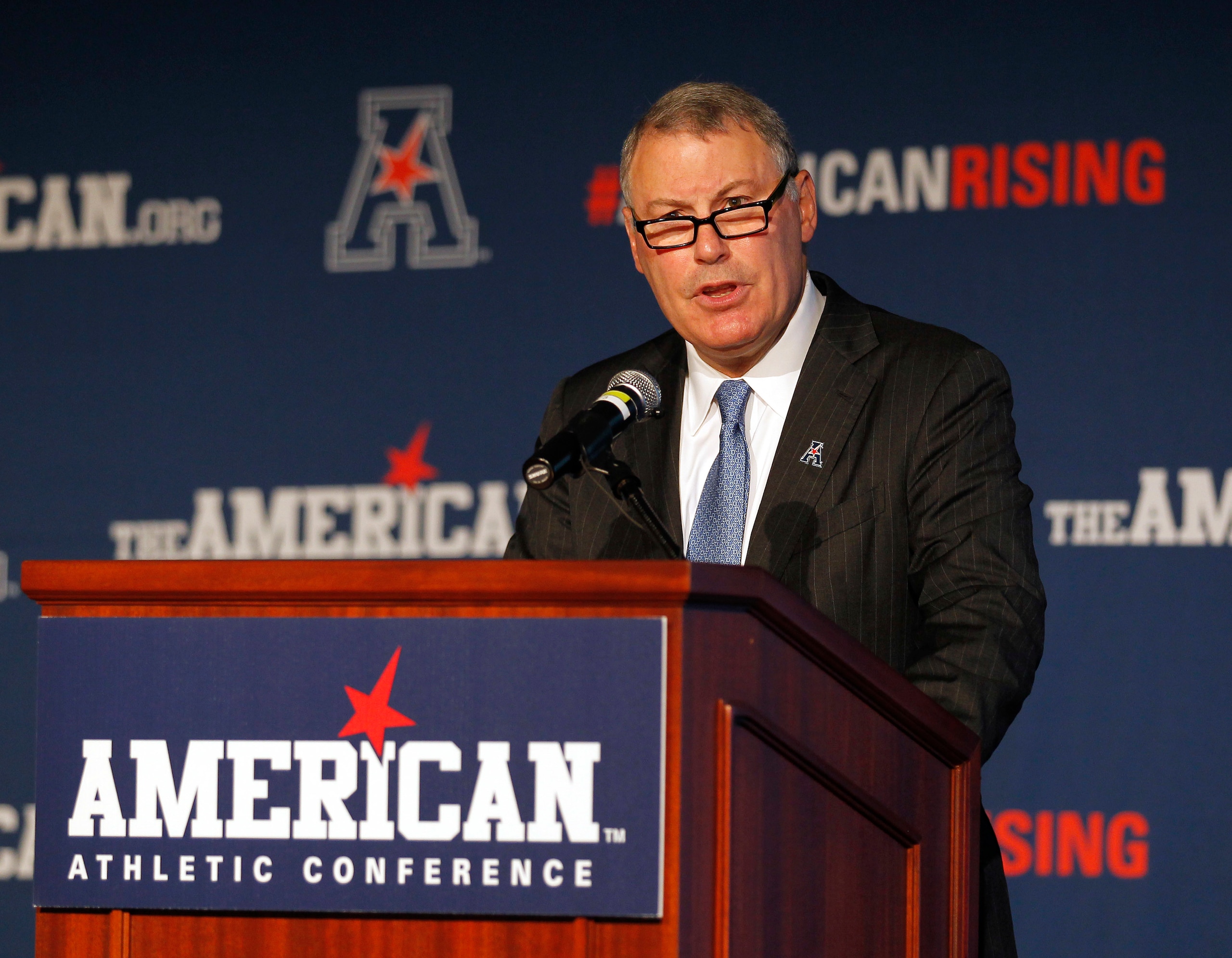 FILE - In this Aug. 4, 2015, file photo, American Athletic Conference Commissioner Mike Aresco addresses the media during an NCAA football media day in Newport, R.I. The AAC gathers for its media day, but hanging over the start of the season is Big 12 expansion. There is a chance the AAC could be lose a member or two (or three or four) when the Big 12 decides to add schools. (AP Photo/Stew Milne, File) FILE - In this Aug. 4, 2015, file photo, American Athletic Conference Commissioner Mike Aresco addresses the media during an NCAA football media day in Newport, R.I. The AAC gathers for its media day, but hanging over the start of the season is Big 12 expansion. There is a chance the AAC could be lose a member or two (or three or four) when the Big 12 decides to add schools. (AP Photo/Stew Milne, File)