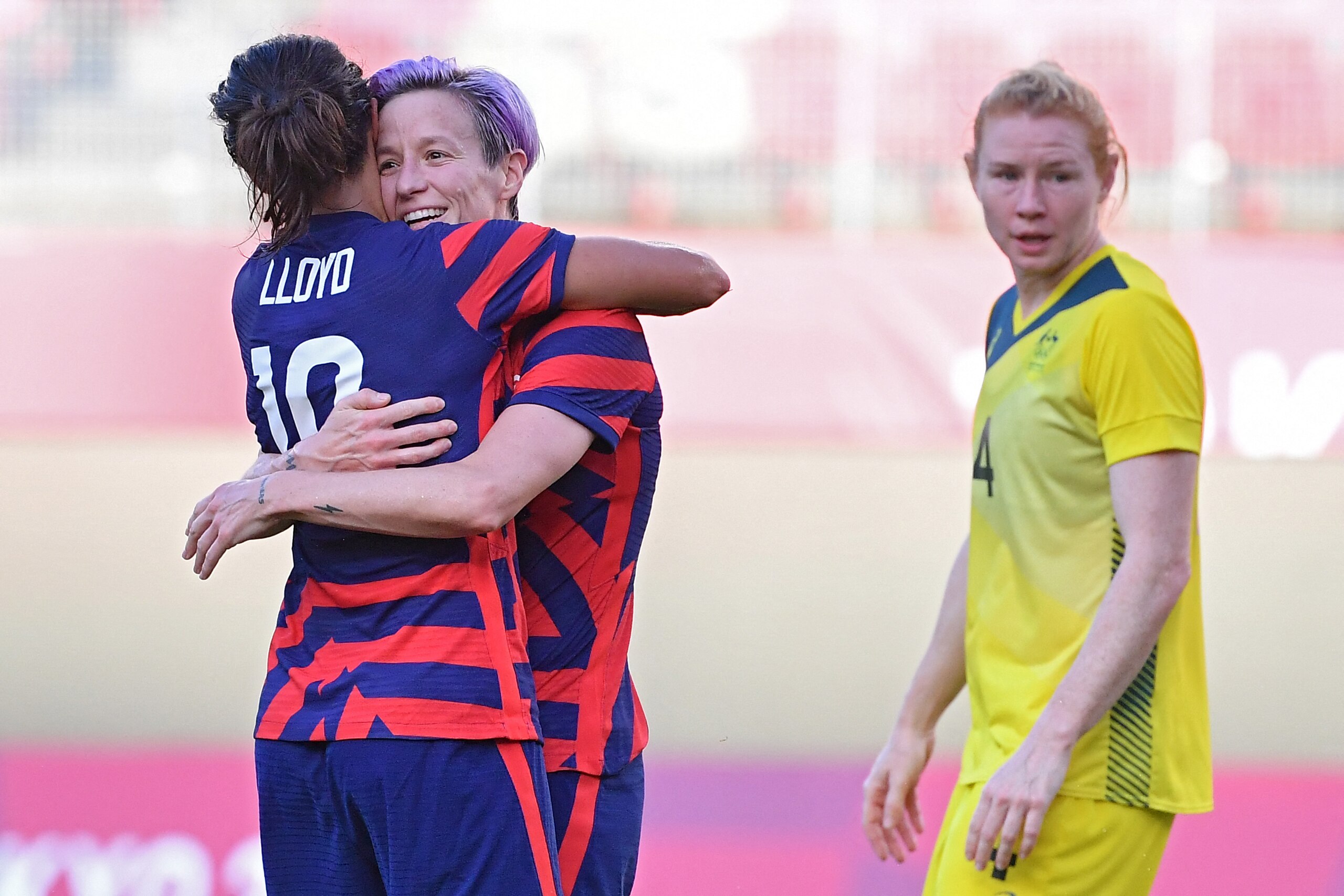 USA's forward Megan Rapinoe (C) is congratulated by teammate forward Carli Lloyd after scoring, as Australia's defender Clare Polkinghorne (R) reacts, during the Tokyo 2020 Olympic Games women's bronze medal football match between Australia and the United States at Ibaraki Kashima Stadium in Kashima city, Ibaraki prefecture on August 5, 2021. (Photo by Tiziana FABI / AFP) (Photo by TIZIANA FABI/AFP via Getty Images)