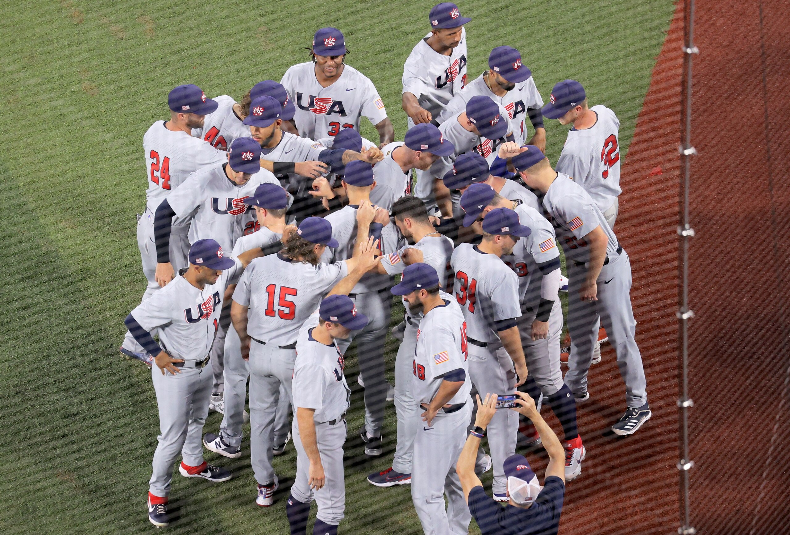 USA's baseball team players and coaches gather in front of dugout prior to the Tokyo 2020 Olympic Games baseball round 2 game between USA and Japan at Yokohama Baseball Stadium in Yokohama, Japan, on August 2, 2021. (Photo by KAZUHIRO FUJIHARA / AFP) (Photo by KAZUHIRO FUJIHARA/AFP via Getty Images)