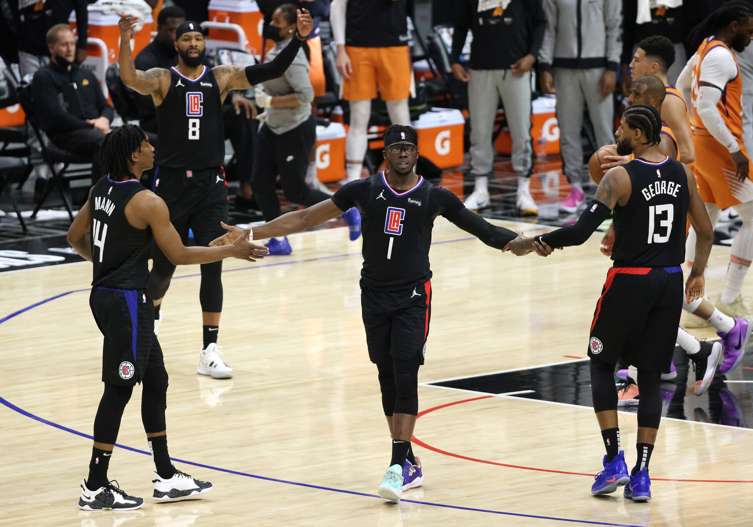 LOS ANGELES, CALIFORNIA - JUNE 30: Reggie Jackson #1 of the LA Clippers reacts to a basket and a foul with teammates Terance Mann #14 and Paul George #13 against the Phoenix Suns during the first half in Game Six of the Western Conference Finals at Staples Center on June 30, 2021 in Los Angeles, California. NOTE TO USER: User expressly acknowledges and agrees that, by downloading and or using this photograph, User is consenting to the terms and conditions of the Getty Images License Agreement. (Photo by Harry How/Getty Images)