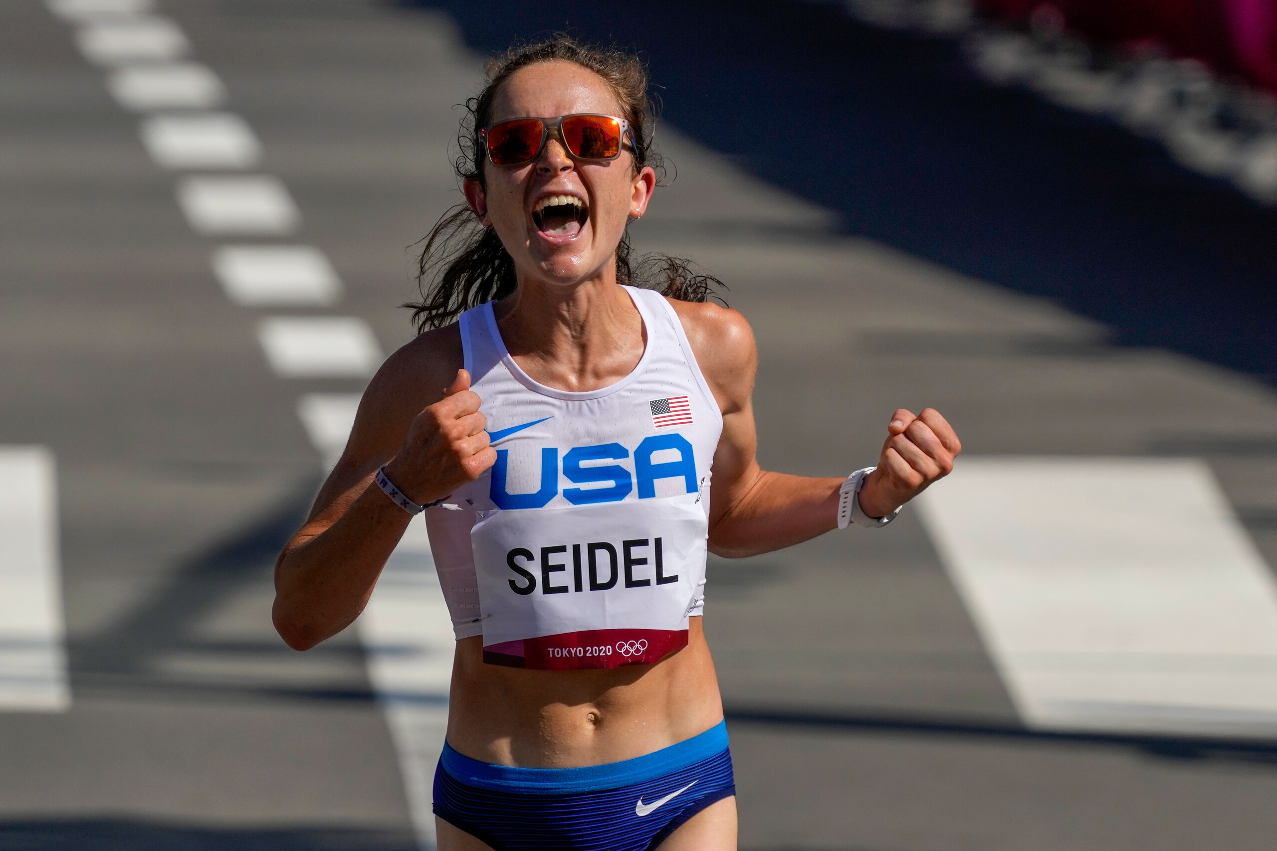 Molly Seidel, of the United States, celebrates as she crosses the finish line to win the bronze medal in the women's marathon at the 2020 Summer Olympics, Saturday, Aug. 7, 2021, in Sapporo, Japan (AP Photo/Shuji Kajiyama)
