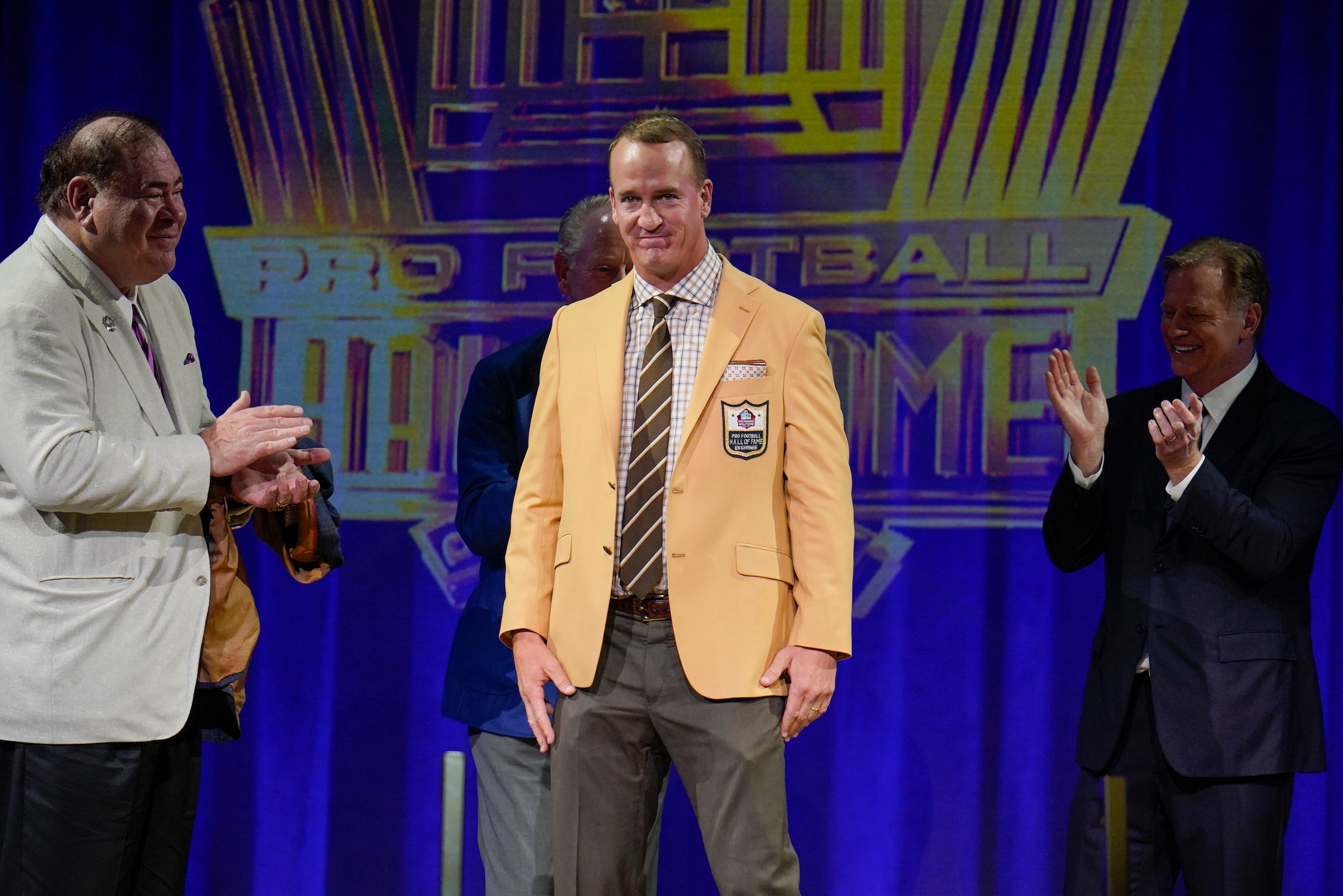 Peyton Manning, a member of the Pro Football Hall of Fame Class of 2021, receives his gold jacket ,during the gold jacket dinner in Canton, Ohio, Friday, Aug. 6, 2021. (AP Photo/Gene J. Puskar)