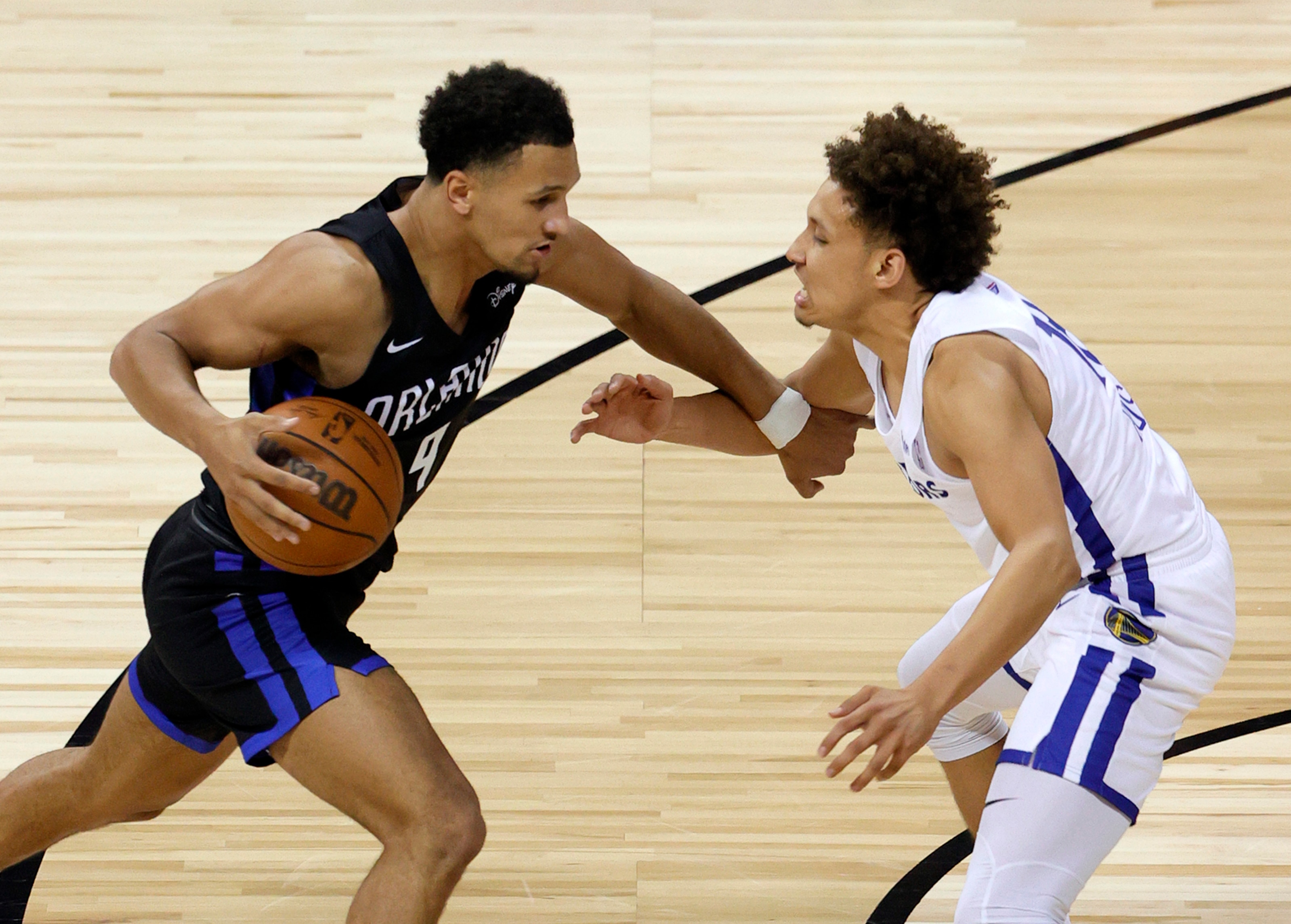 LAS VEGAS, NEVADA - AUGUST 09:  Jalen Suggs #4 of the Orlando Magic brings the ball up the court against Colbey Ross #18 of the Golden State Warriors during the 2021 NBA Summer League at the Thomas & Mack Center on August 9, 2021 in Las Vegas, Nevada. NOTE TO USER: User expressly acknowledges and agrees that, by downloading and or using this photograph, User is consenting to the terms and conditions of the Getty Images License Agreement.  (Photo by Ethan Miller/Getty Images)