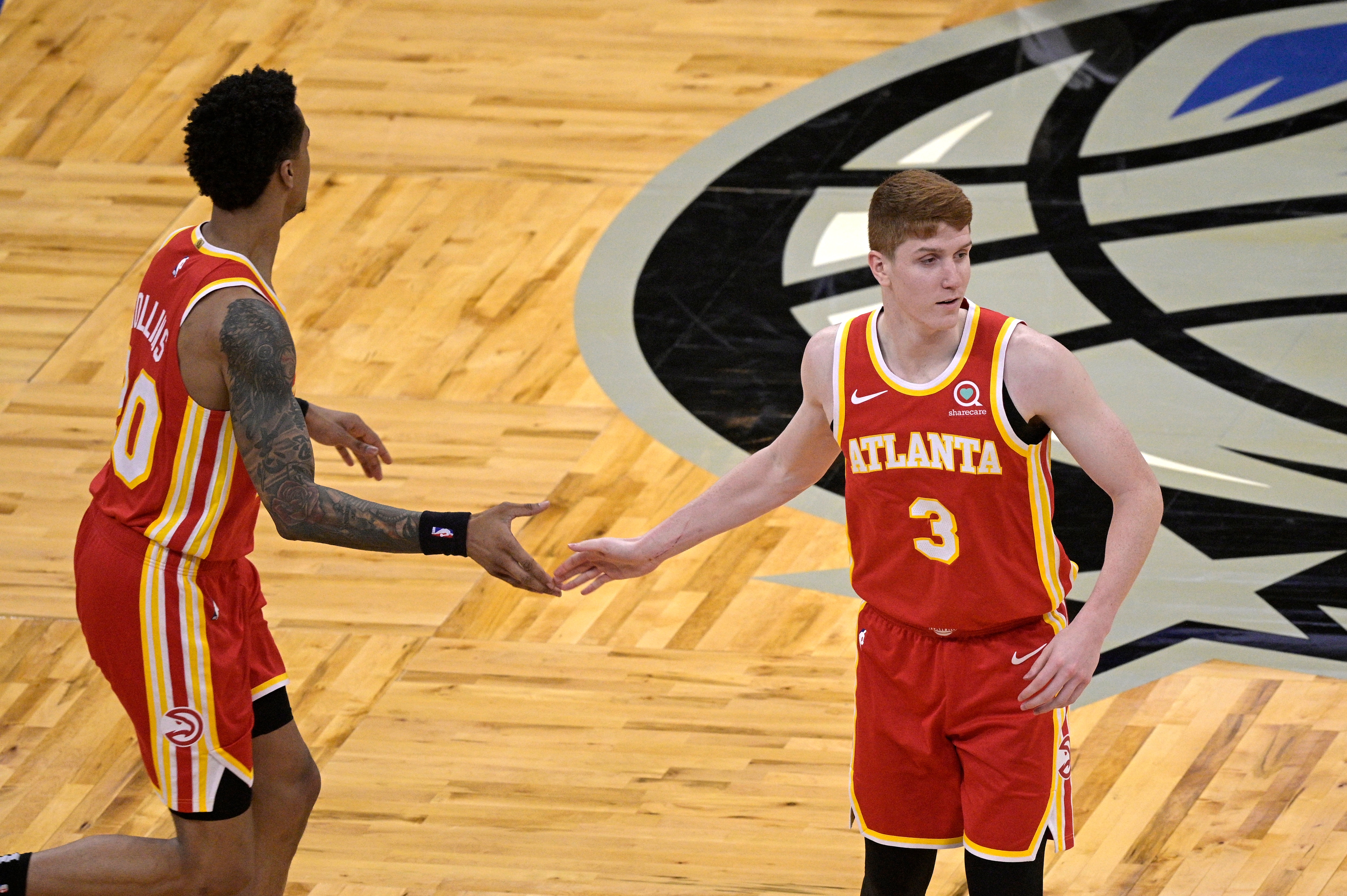 Atlanta Hawks guard Kevin Huerter (3) is congratulated by forward John Collins (20) after Huerter scored during the second half of an NBA basketball game against the Orlando Magic, Wednesday, March 3, 2021, in Orlando, Fla. (AP Photo/Phelan M. Ebenhack)