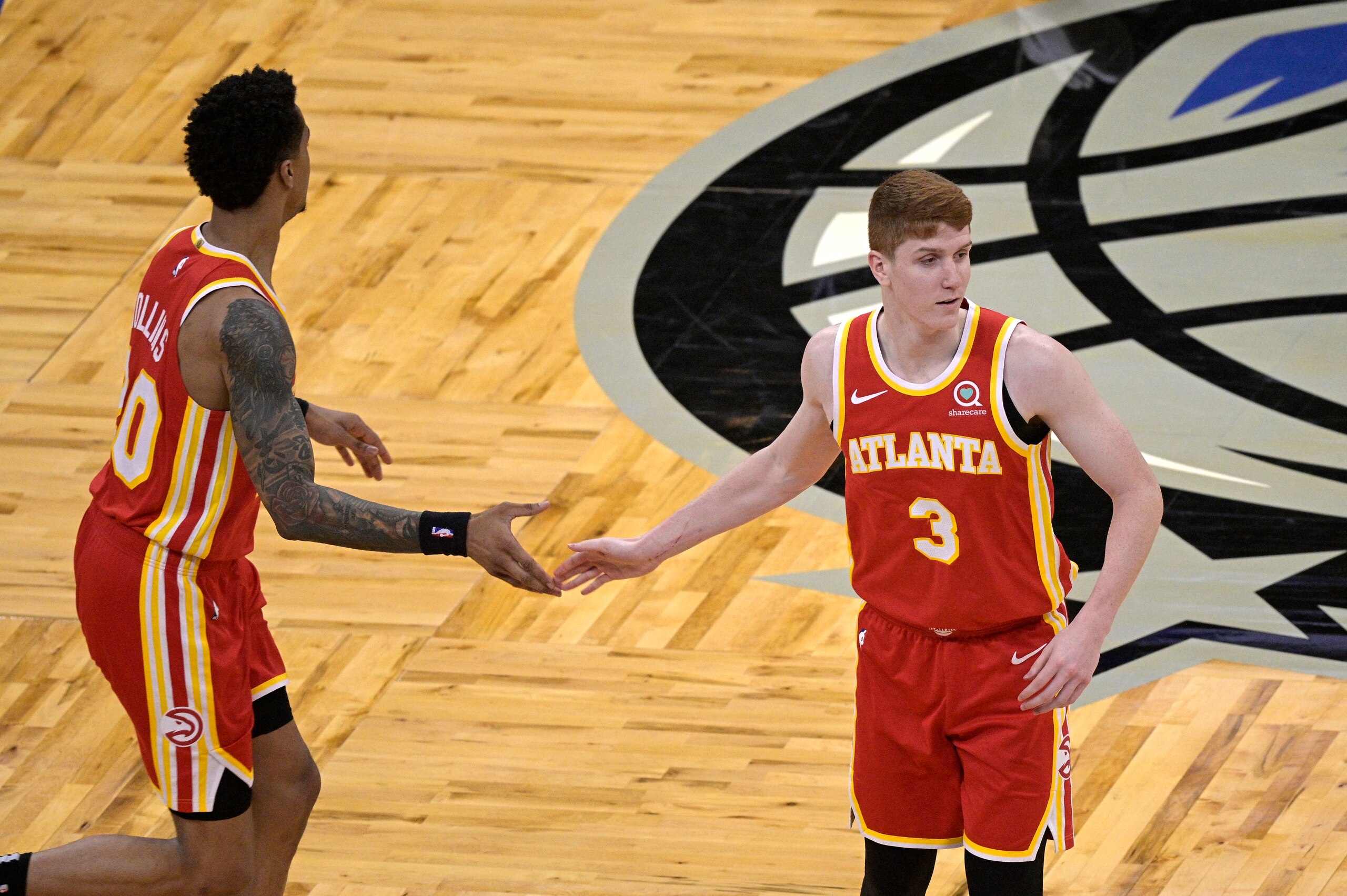 Atlanta Hawks guard Kevin Huerter (3) is congratulated by forward John Collins (20) after Huerter scored during the second half of an NBA basketball game against the Orlando Magic, Wednesday, March 3, 2021, in Orlando, Fla. (AP Photo/Phelan M. Ebenhack)