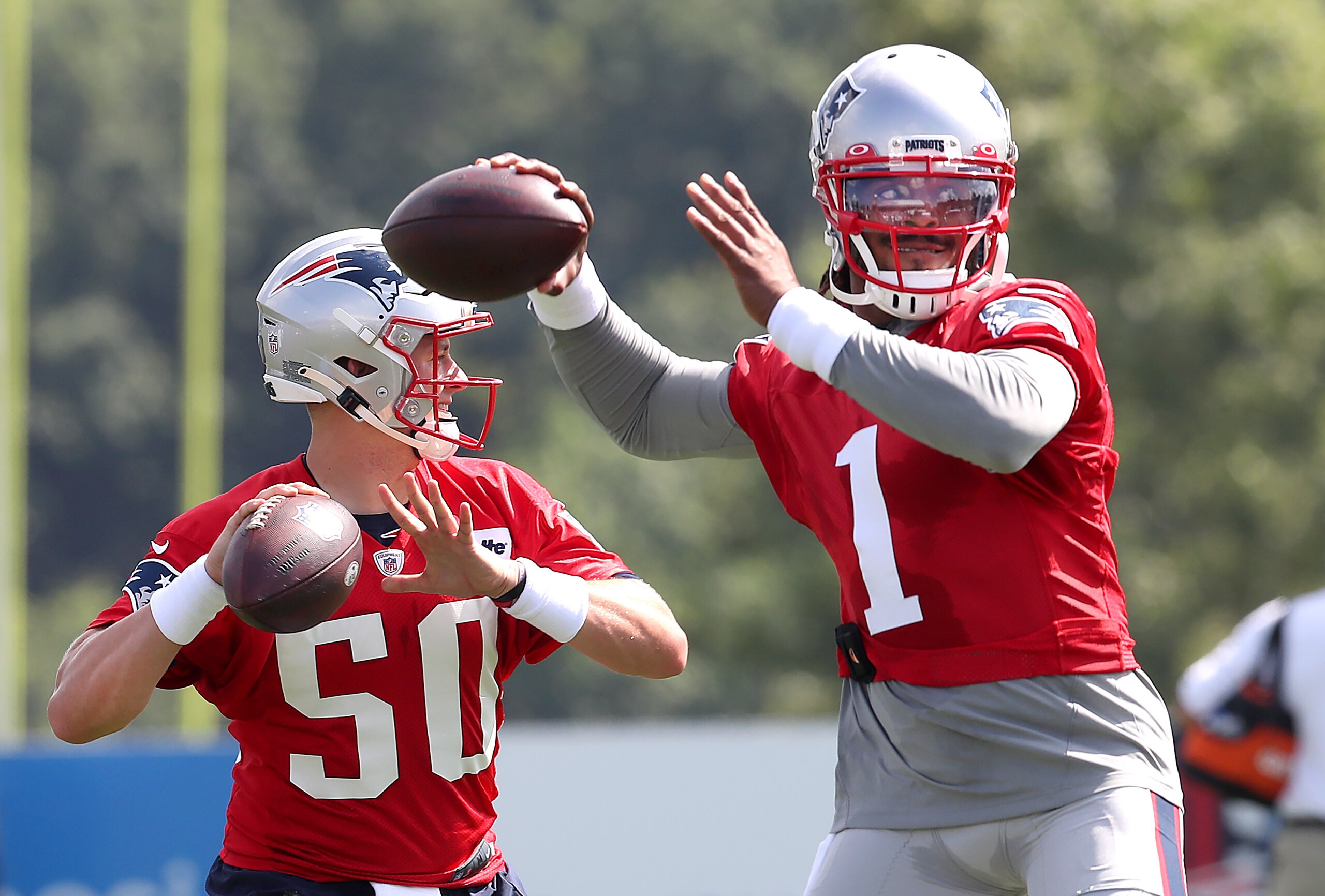 Foxborough, MA - July 30: Quarterbacks Mac Jones, left, and Cam Newton fire passes during a drill. The New England Patriots holdDay 3 of training camp at the Gillette Stadium practice field in Foxborough, MA on July 30, 2021. (Photo by John Tlumacki/The Boston Globe via Getty Images)