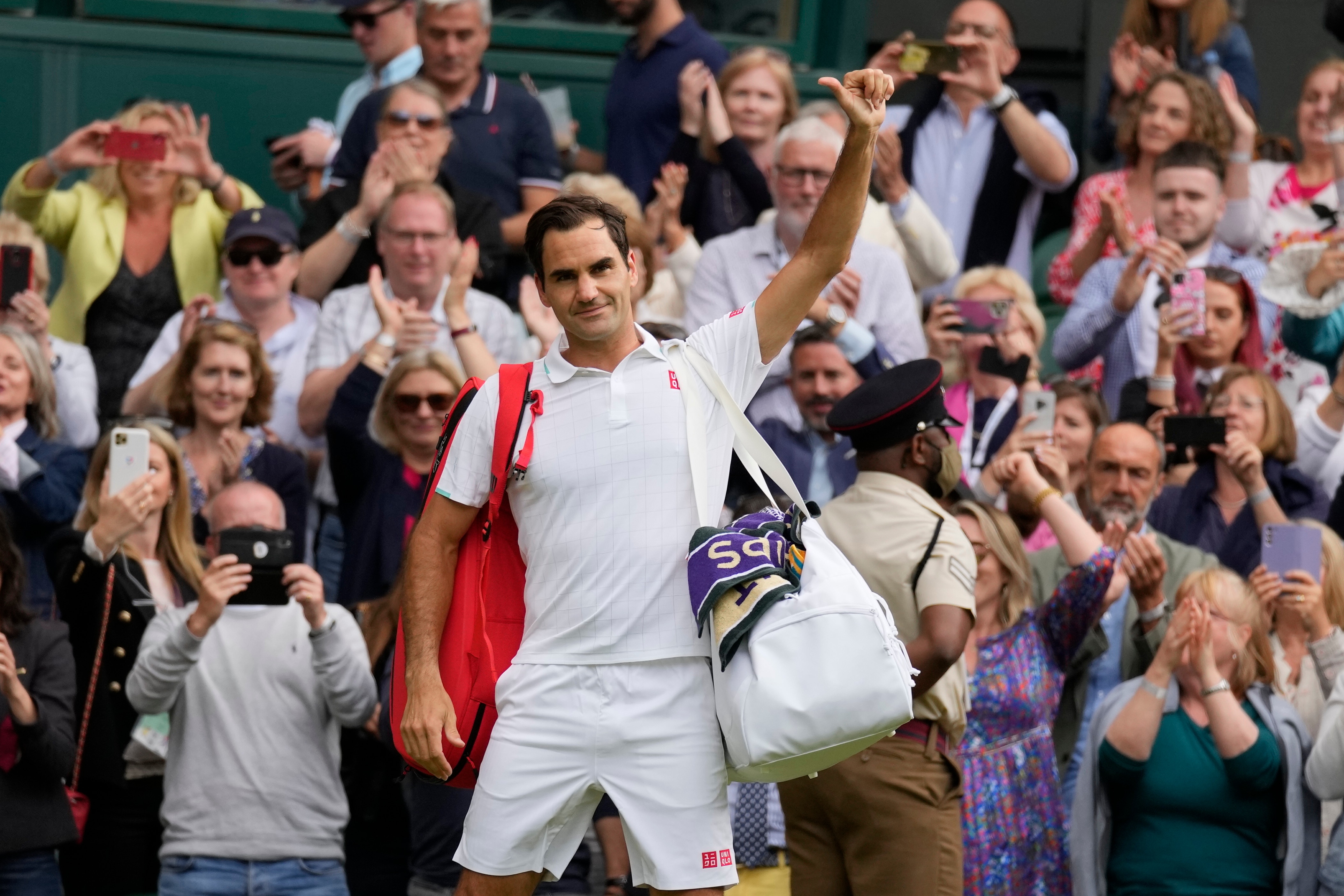 Switzerland's Roger Federer leaves the court after being defeated by Poland's Hubert Hurkacz during the men's singles quarterfinals match on day nine of the Wimbledon Tennis Championships in London, Wednesday, July 7, 2021. (AP Photo/Kirsty Wigglesworth)