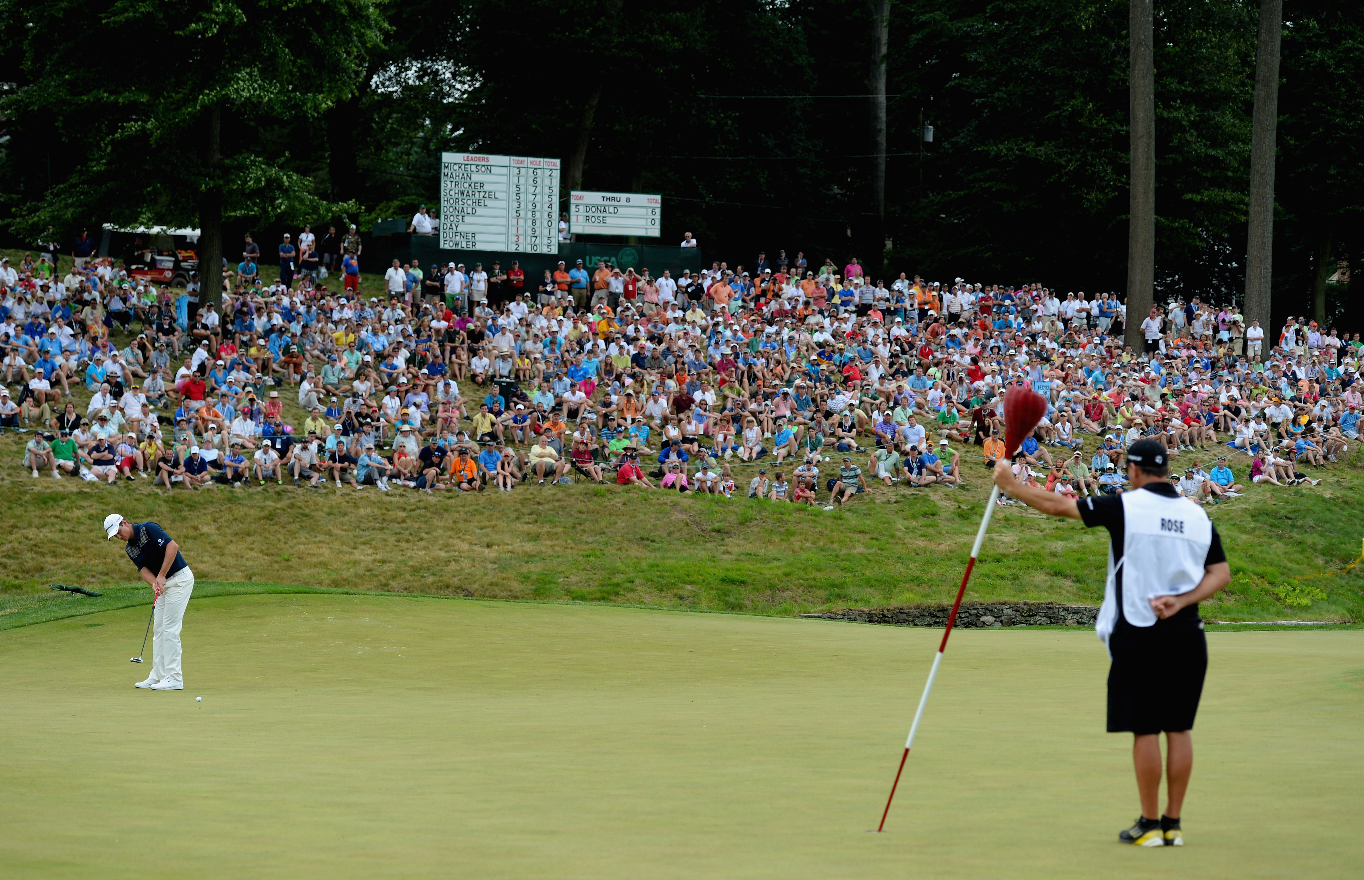 ARDMORE, PA - JUNE 16:  Justin Rose of England putts on the ninth green as caddie Mark Fulcher holds the wicker basket flagstick during the final round of the 113th U.S. Open at Merion Golf Club on June 16, 2013 in Ardmore, Pennsylvania.  (Photo by Ross Kinnaird/Getty Images) 