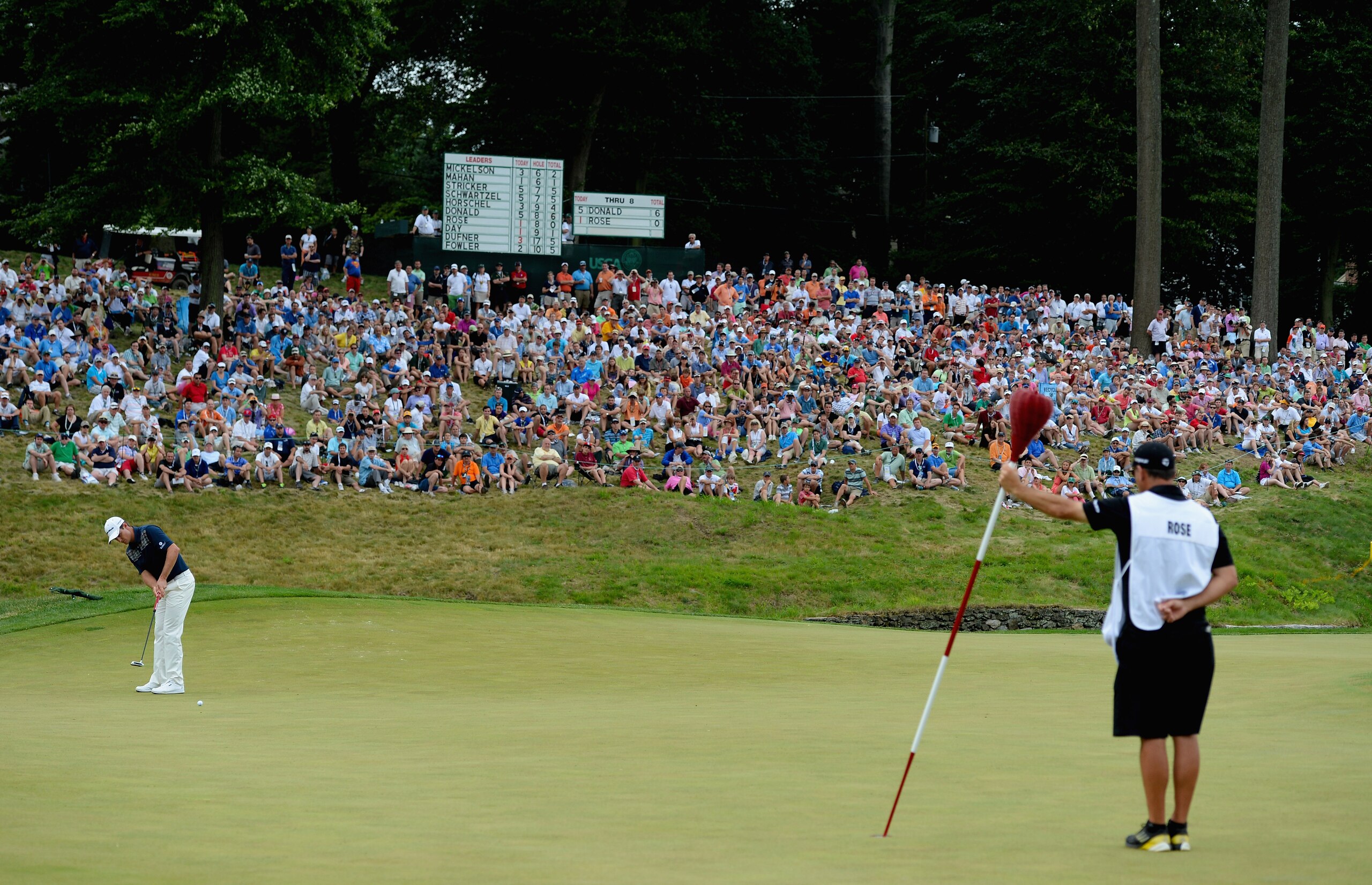 ARDMORE, PA - JUNE 16:  Justin Rose of England putts on the ninth green as caddie Mark Fulcher holds the wicker basket flagstick during the final round of the 113th U.S. Open at Merion Golf Club on June 16, 2013 in Ardmore, Pennsylvania.  (Photo by Ross Kinnaird/Getty Images) 