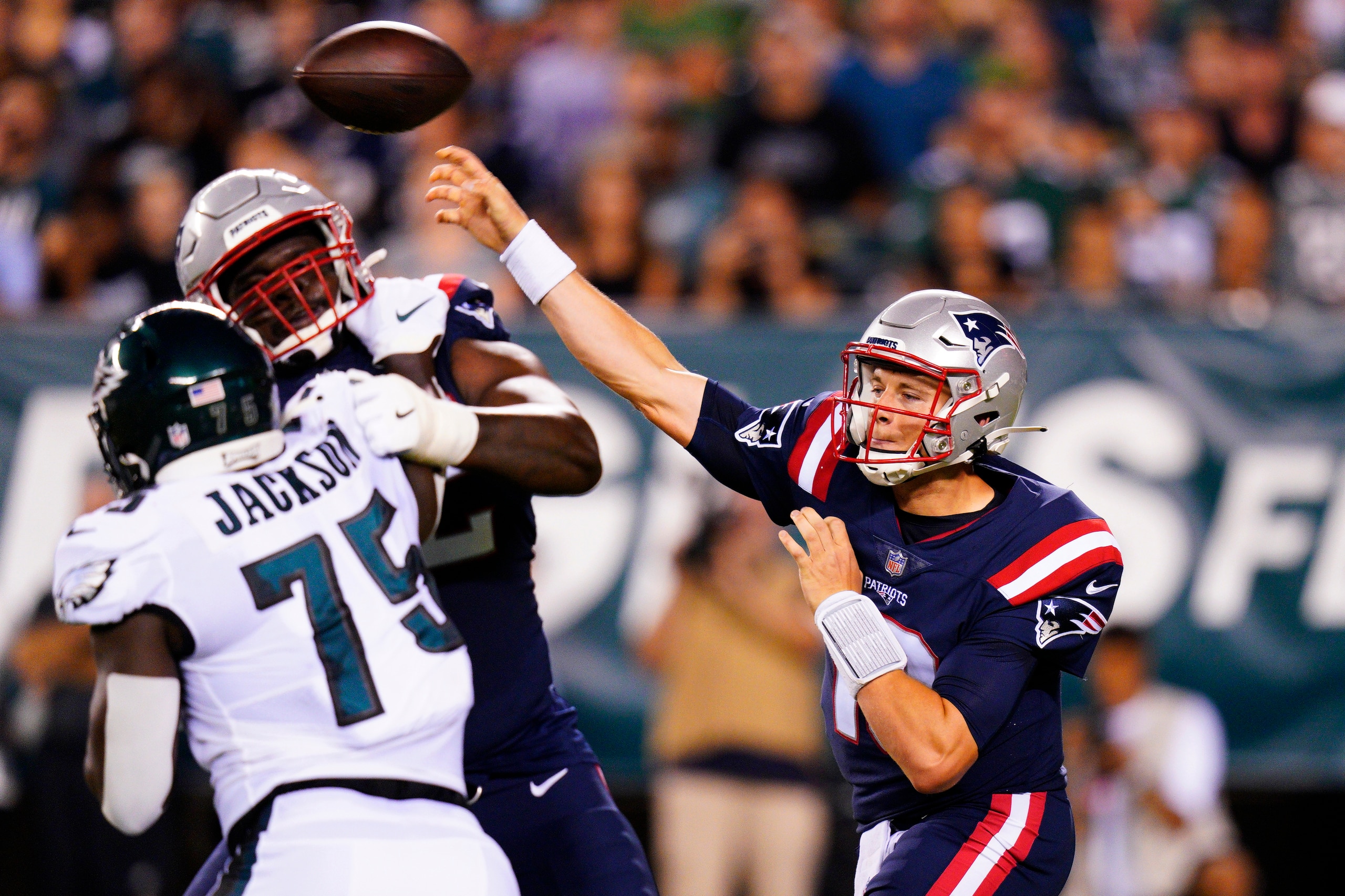 New England Patriots' Mac Jones throws a pass over Philadelphia Eagles' Tarron Jackson during the first half of a preseason NFL football game Thursday, Aug. 19, 2021, in Philadelphia. (AP Photo/Chris Szagola)