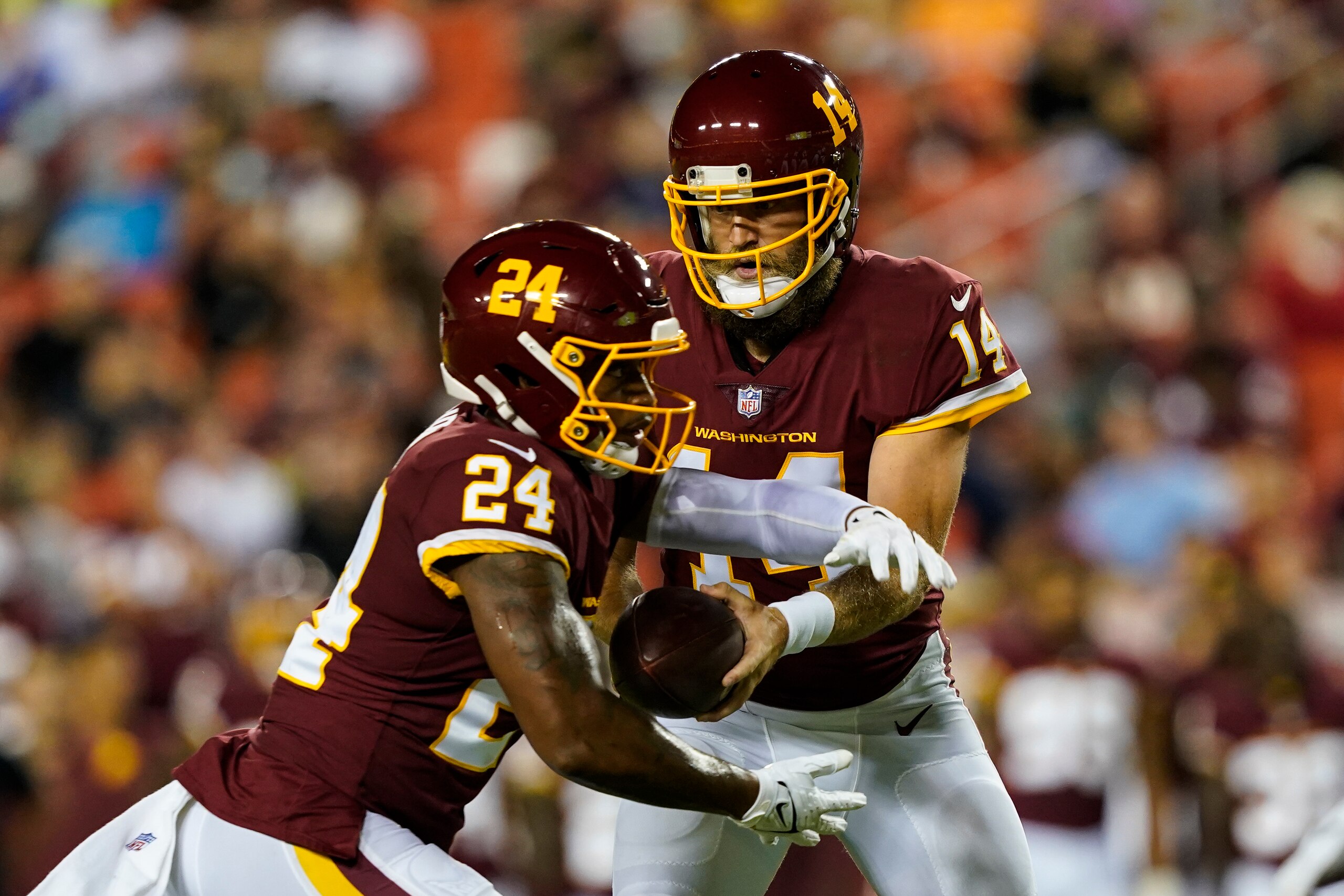 Washington Football Team quarterback Ryan Fitzpatrick (14) hands the ball off to running back Antonio Gibson (24) during the first half of a preseason NFL football game against the Cincinnati Bengals, Friday, Aug. 20, 2021, in Landover, Md. (AP Photo/Susan Walsh)