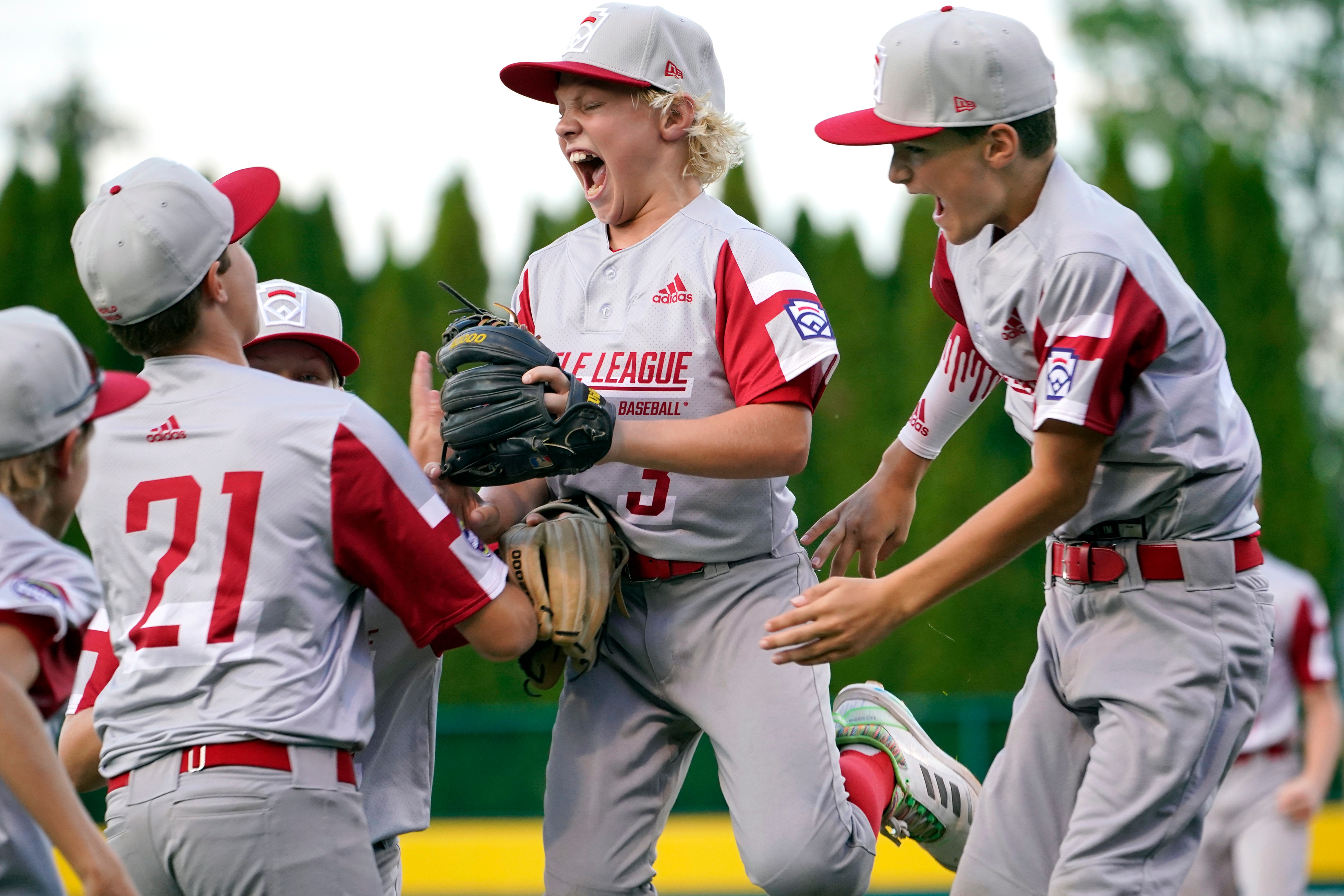 Sioux Falls, S.D.'s Maddux Munson (21), Cason Mediger (3) and Brayson Fox (4) celebrate their win over Lafayette, La., in a baseball game at the Little League World Series in South Williamsport, Pa., Friday, Aug. 20, 2021. (AP Photo/Tom E. Puskar)