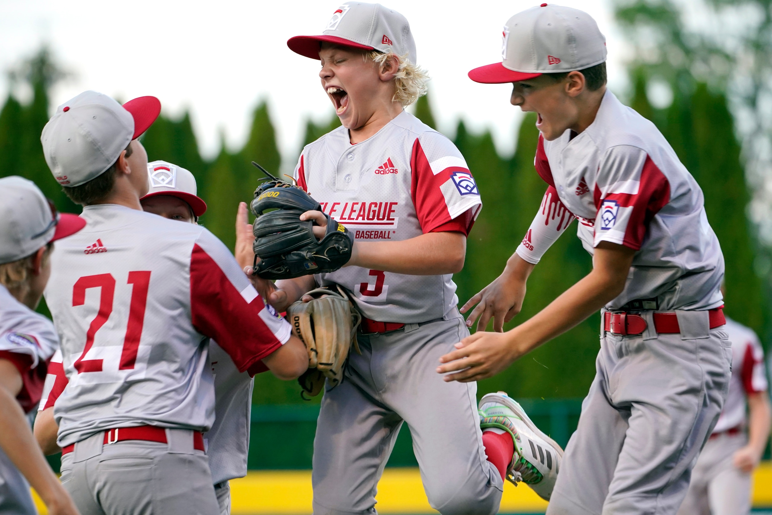 Sioux Falls, S.D.'s Maddux Munson (21), Cason Mediger (3) and Brayson Fox (4) celebrate their win over Lafayette, La., in a baseball game at the Little League World Series in South Williamsport, Pa., Friday, Aug. 20, 2021. (AP Photo/Tom E. Puskar)