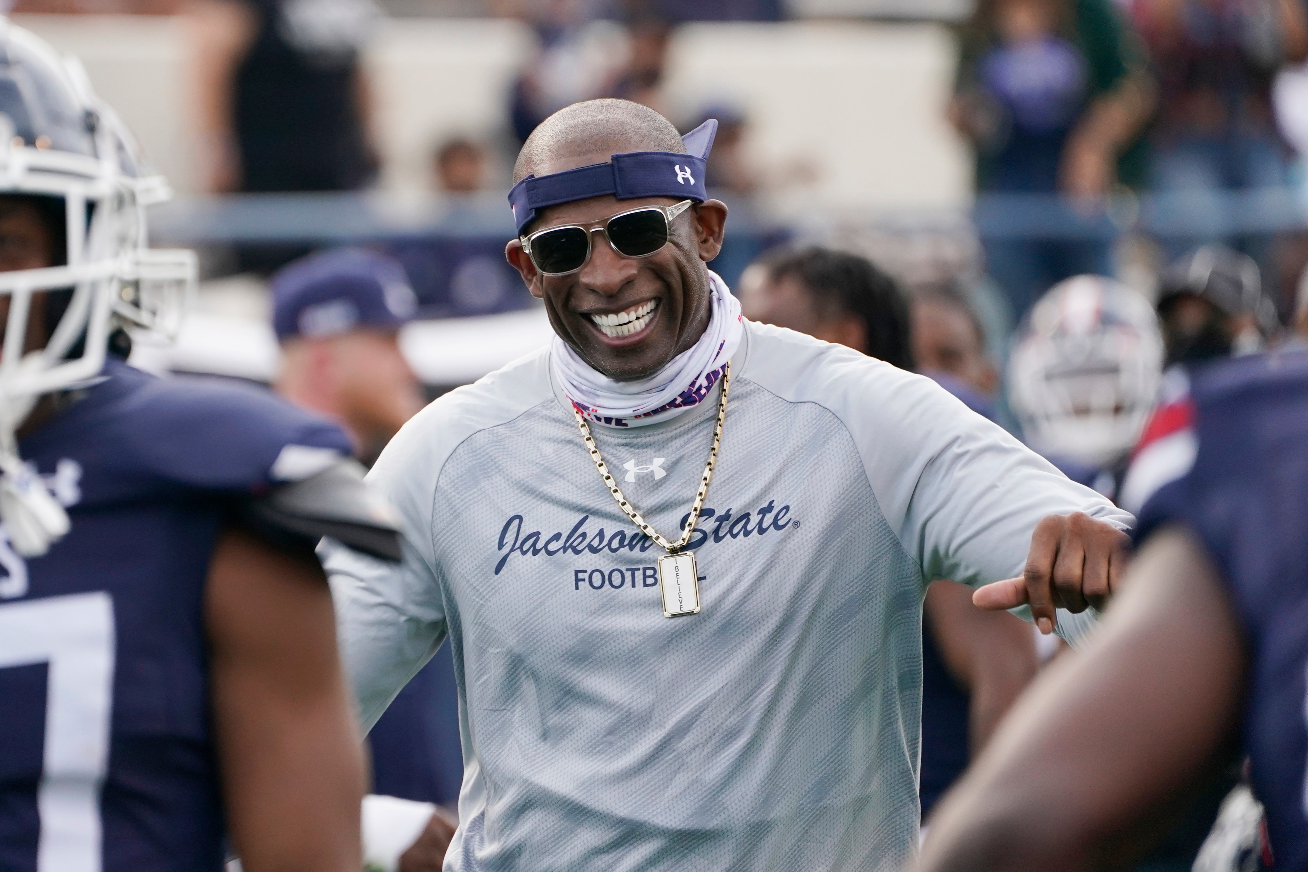 Jackson State football coach Deion Sanders smiles as he greets his defensive squad after they had recovered a Mississippi Valley State fumble for a touchdown during the second half of an NCAA college football game, Sunday, March 14, 2021, in Jackson, Miss. (AP Photo/Rogelio V. Solis)