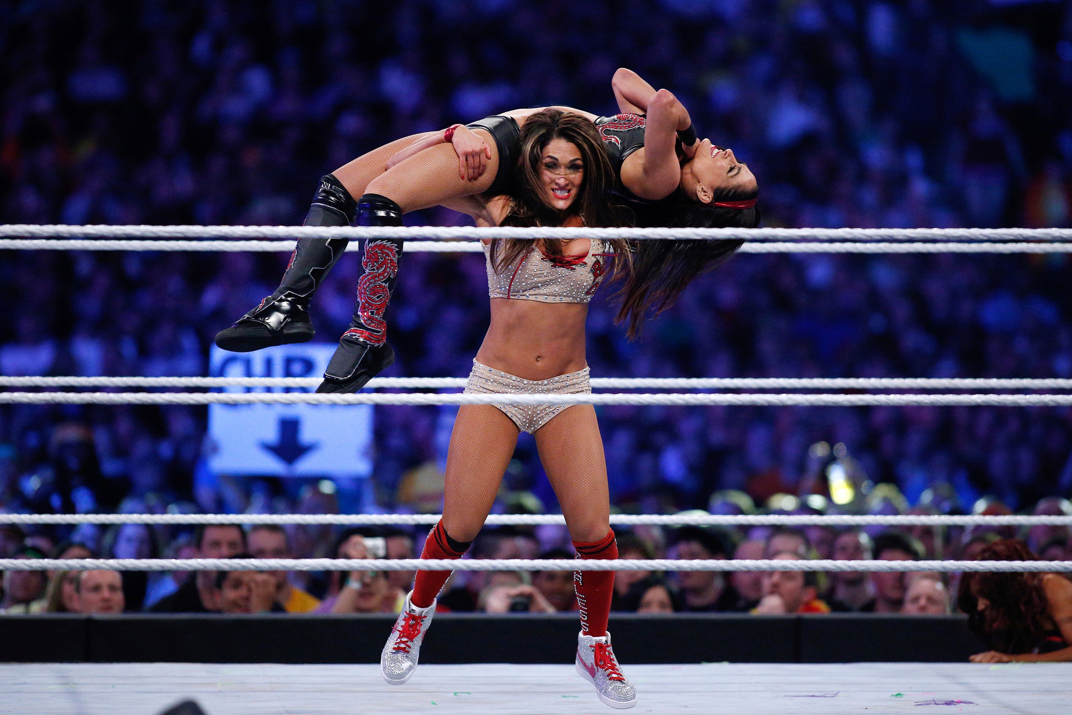 FILE - In this April 6, 2014, file photo, Brie Bella and Nikki Bella, known as the Bella Twins, compete during Wrestlemania XXX at the Mercedes-Benz Super Dome in New Orleans. (Jonathan Bachman/AP Images for WWE)