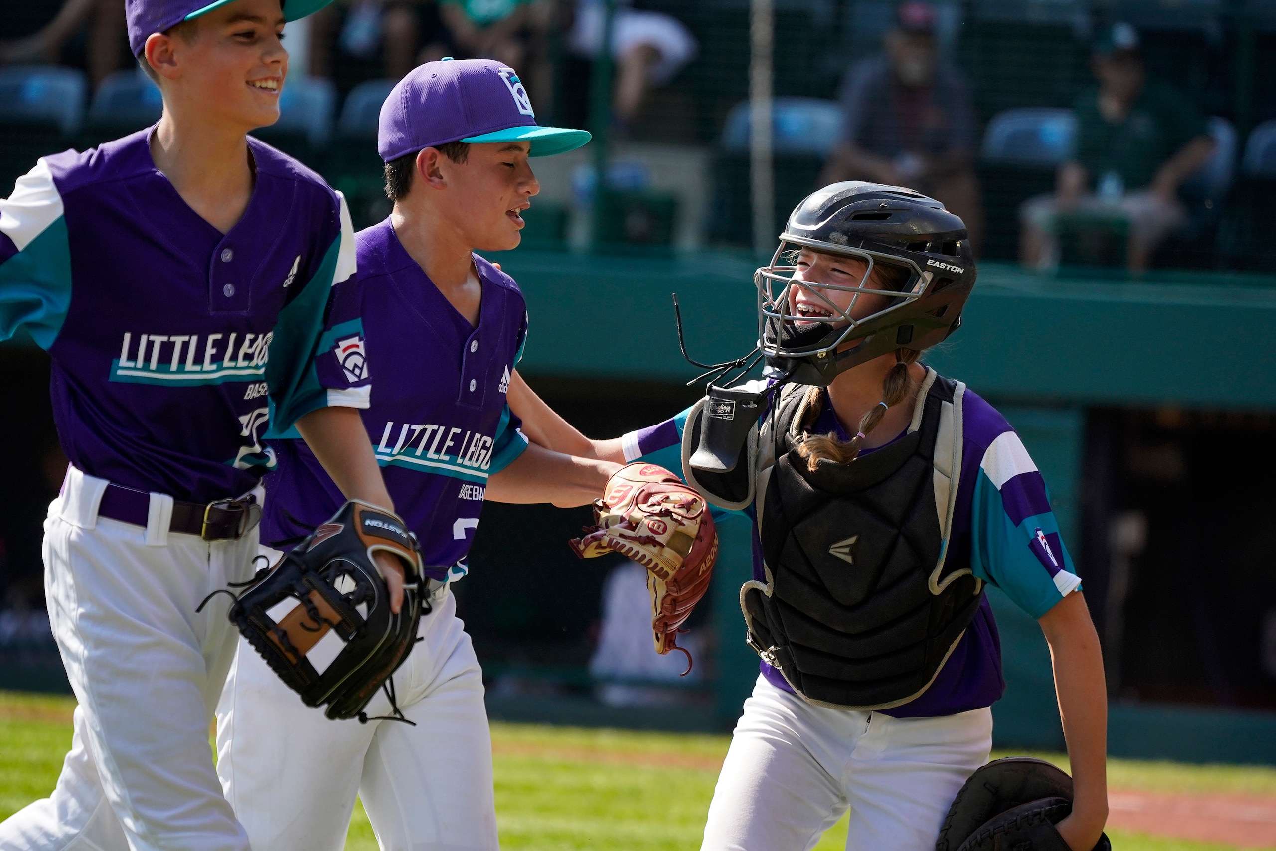Abilene, Texas catcher Ella Bruning, right, celebrates with pitcher Dylan Regata, center, after retiring the side during the first inning of a baseball game against Toms River, N.J. at the Little League World Series in South Willitamsport, Pa., Tuesday, Aug. 24, 2021. (AP Photo/Gene J. Puskar)