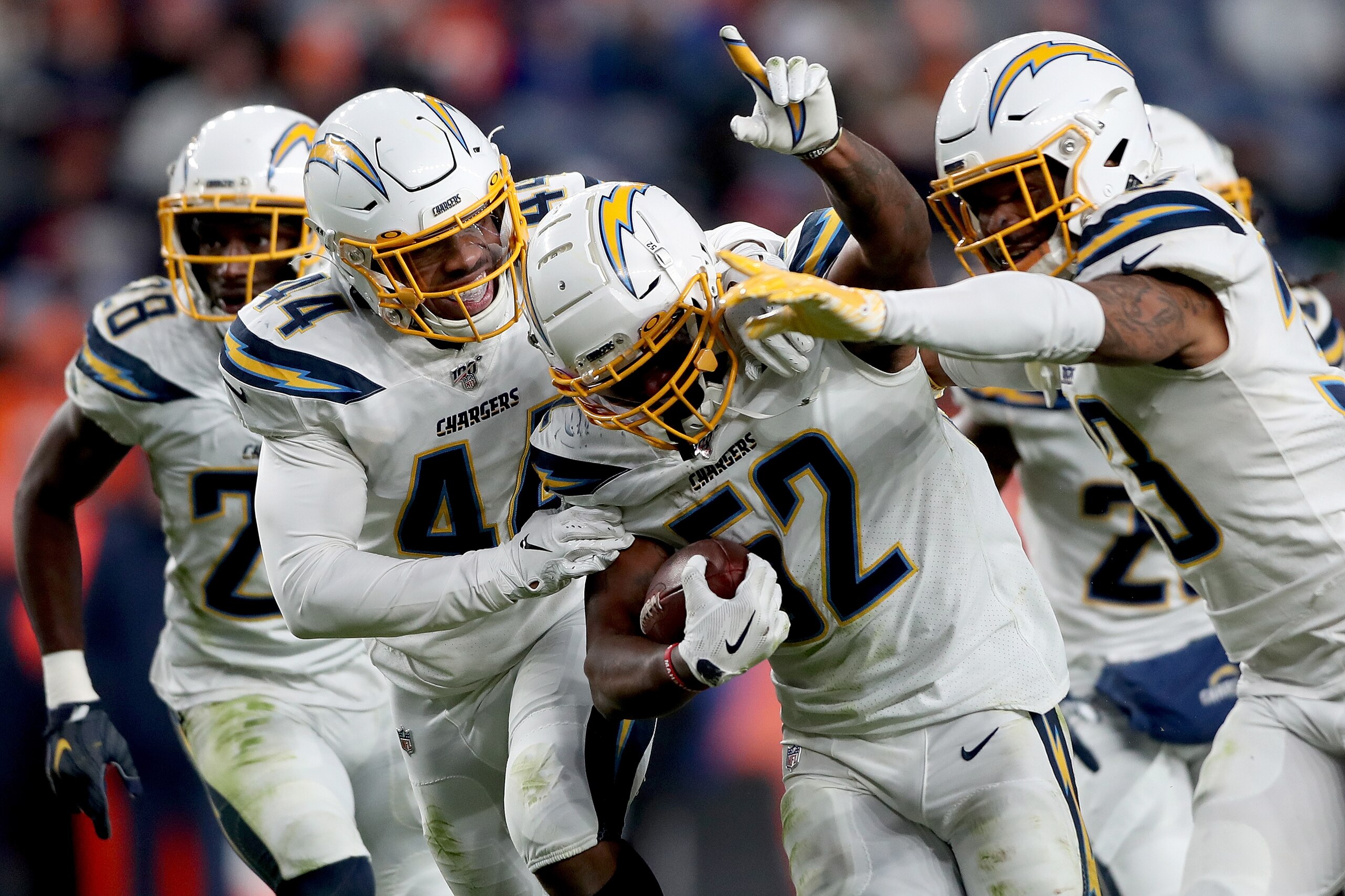 DENVER, COLORADO - DECEMBER 01: Denzel Perryman #52 of the Los Angeles Chargers celebrates with Kyzir White #44 and Derwin James #33 after making an interception against the Denver Broncos in the fourth quarter at Empower Field at Mile High on December 01, 2019 in Denver, Colorado. (Photo by Matthew Stockman/Getty Images)