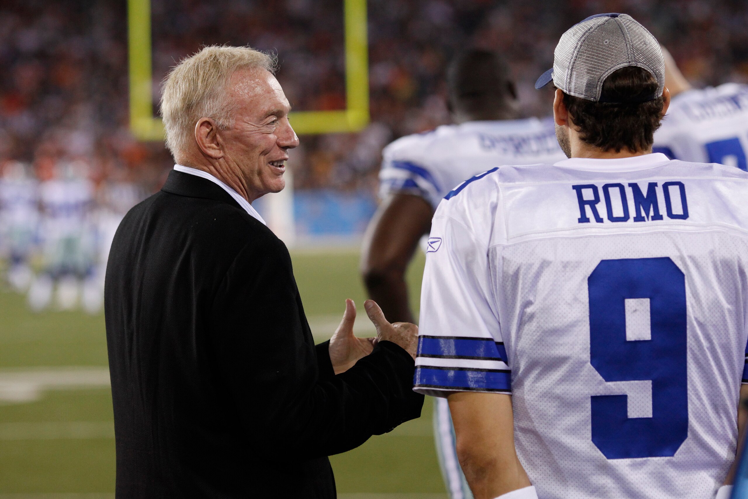 CANTON, OH - AUGUST 8: Dallas Cowboys owner Jerry Jones talks with Tony Romo #9 on the sidelines against the Cincinnati Bengals during the 2010 Pro Football Hall of Fame Game at the Pro Football Hall of Fame Field at Fawcett Stadium on August 8, 2010 in Canton, Ohio. The Cowboys defeated the Bengals 16-7. (Photo by Joe Robbins/Getty Images)
