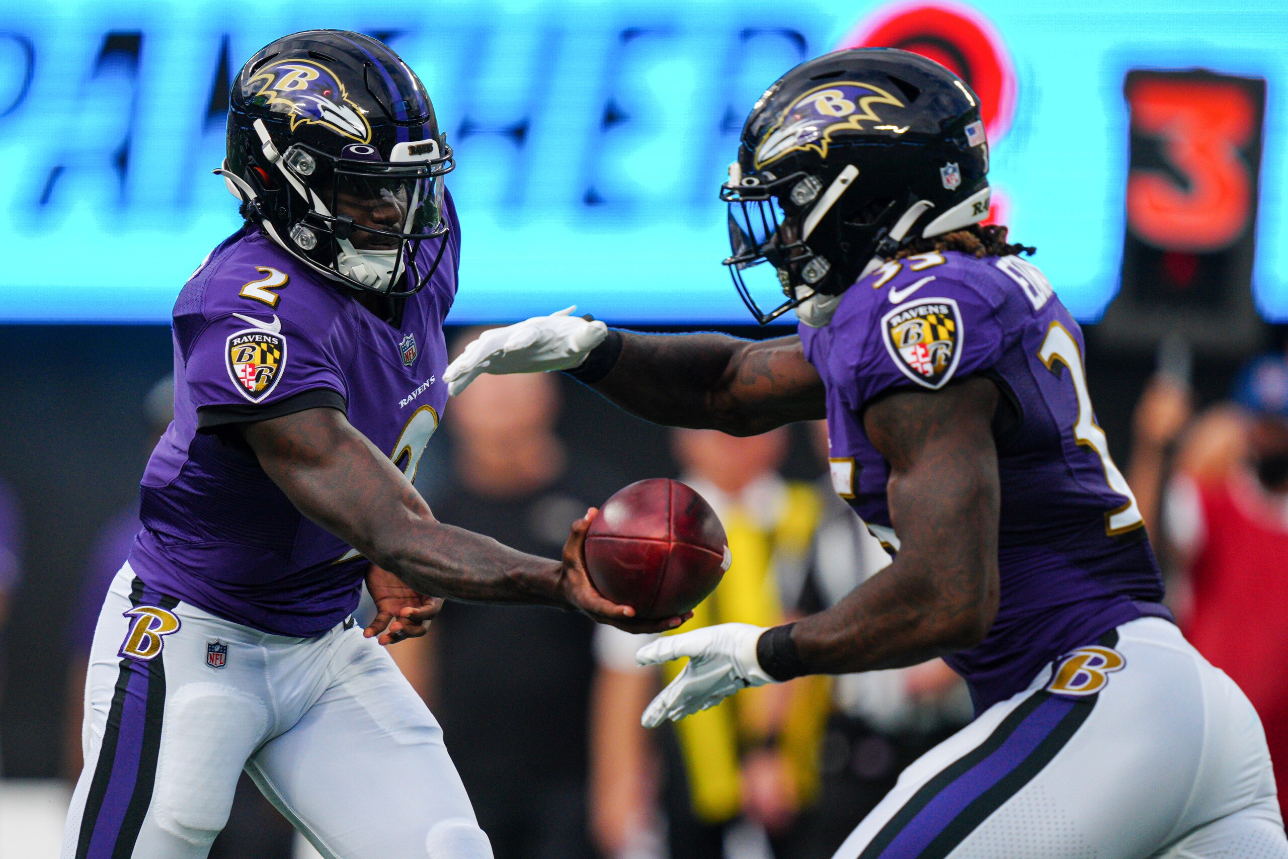 Baltimore Ravens quarterback Tyler Huntley hands the ball off to running back Gus Edwards during the first half of a preseason NFL football game against the Carolina Panthers Saturday, Aug. 21, 2021, in Charlotte, N.C. (AP Photo/Jacob Kupferman)