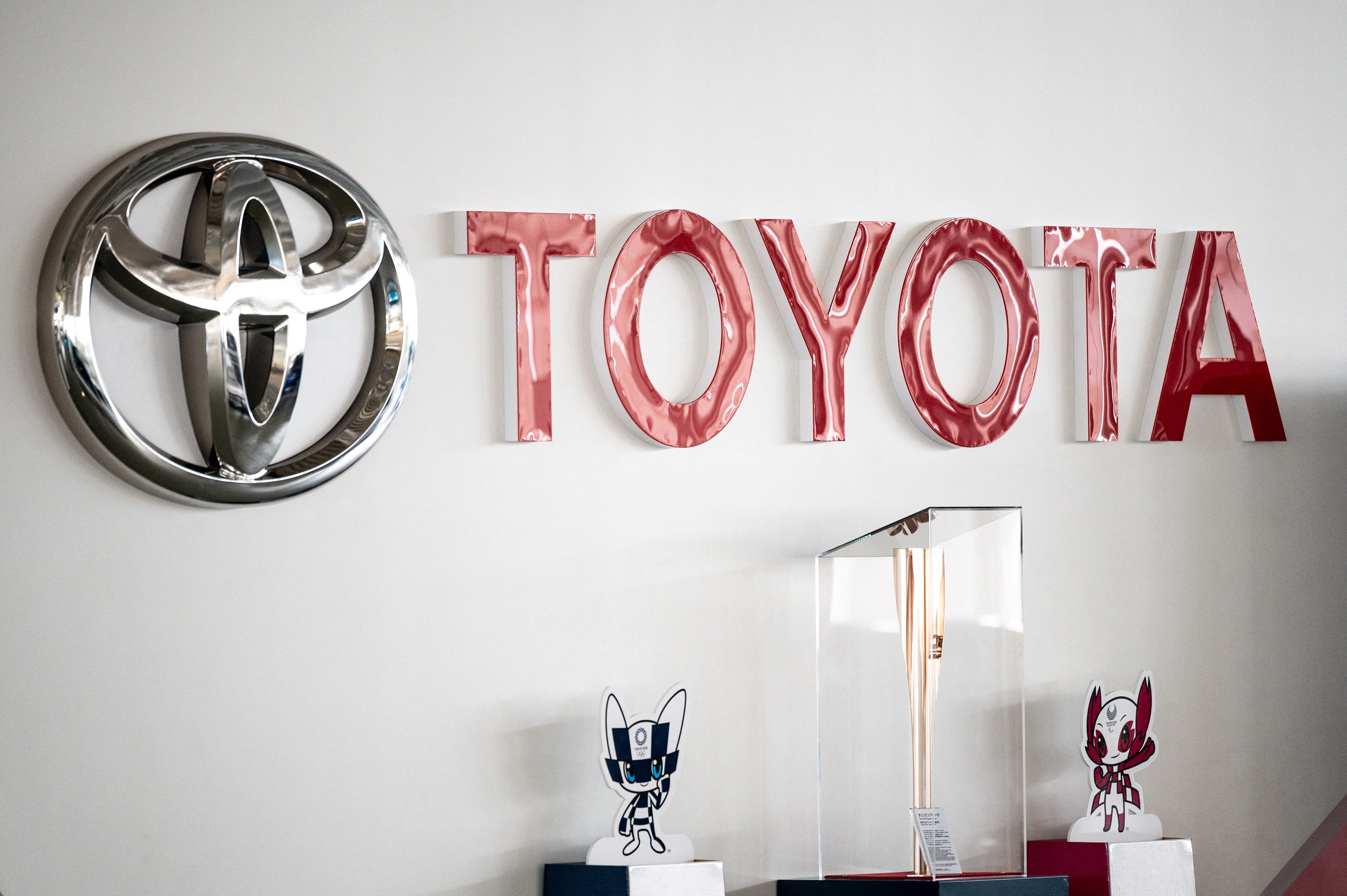 This picture shows a Toyota logo next to the Tokyo 2020 Olympic and Paralympic Games mascots and torch at a closed Toyota showroom in Tokyo on May 12, 2021. (Photo by Philip FONG / AFP) (Photo by PHILIP FONG/AFP via Getty Images)