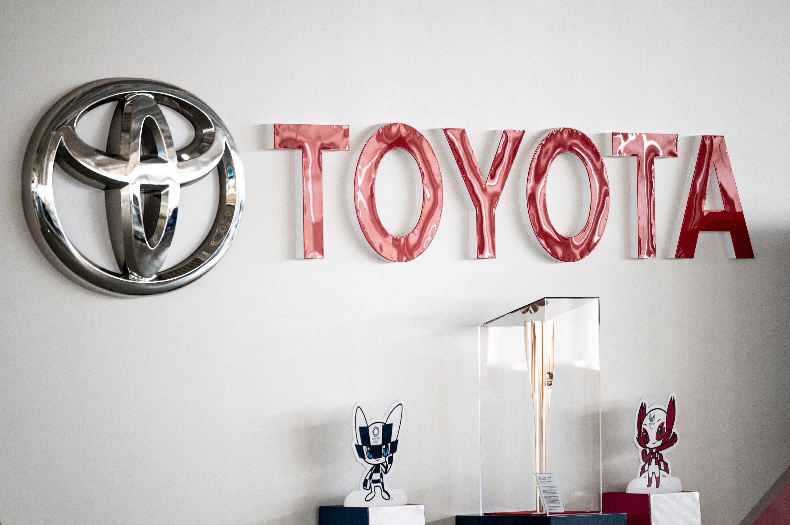 This picture shows a Toyota logo next to the Tokyo 2020 Olympic and Paralympic Games mascots and torch at a closed Toyota showroom in Tokyo on May 12, 2021. (Photo by Philip FONG / AFP) (Photo by PHILIP FONG/AFP via Getty Images)