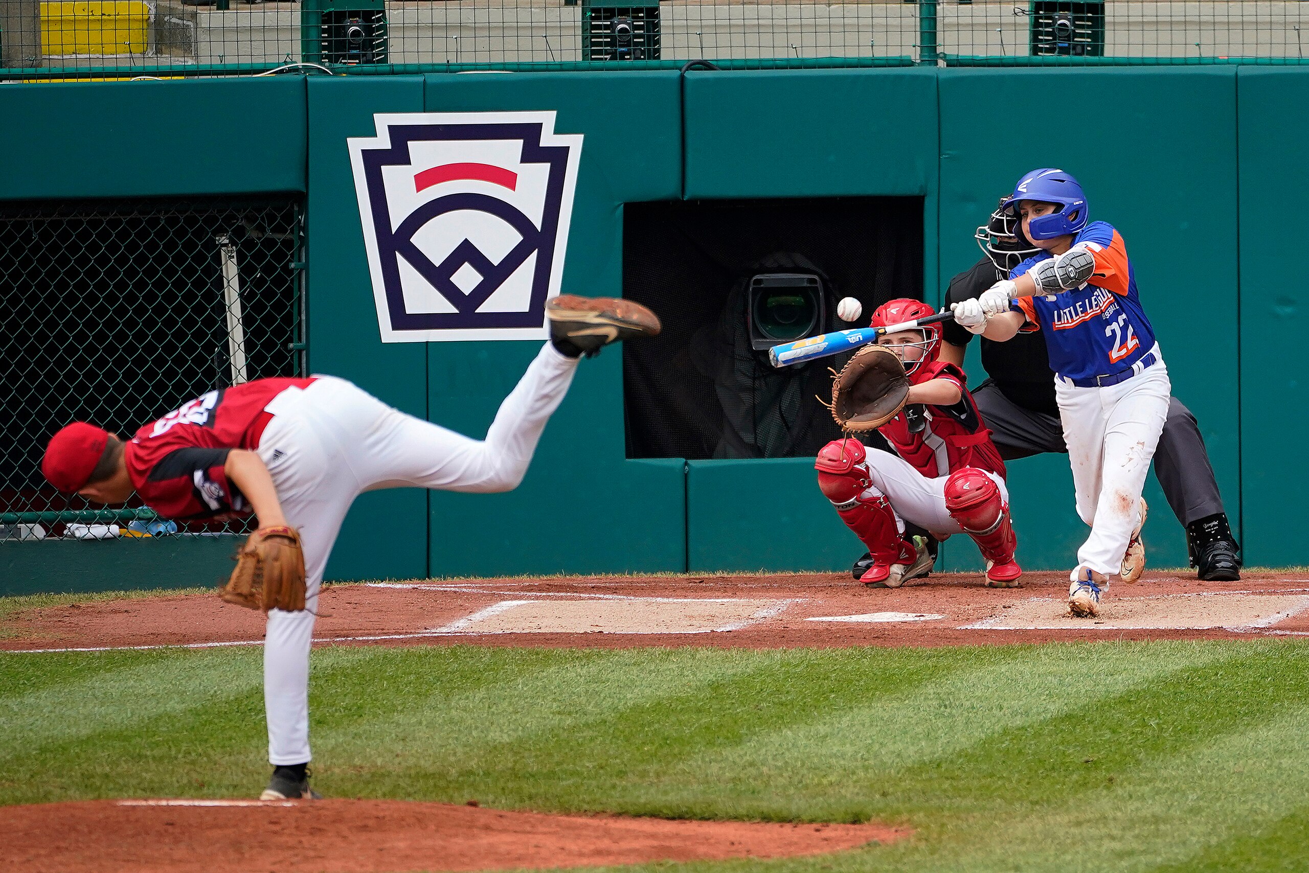 Taylor, Mich.'s Jackson Surma (22) hits a double off Hamilton, Ohio's Chance Retherford, left, driving in two runs, during the first inning of the Little League World Series Championship baseball game in South Williamsport, Pa., Sunday, Aug. 29, 2021. (AP Photo/Tom E. Puskar)
