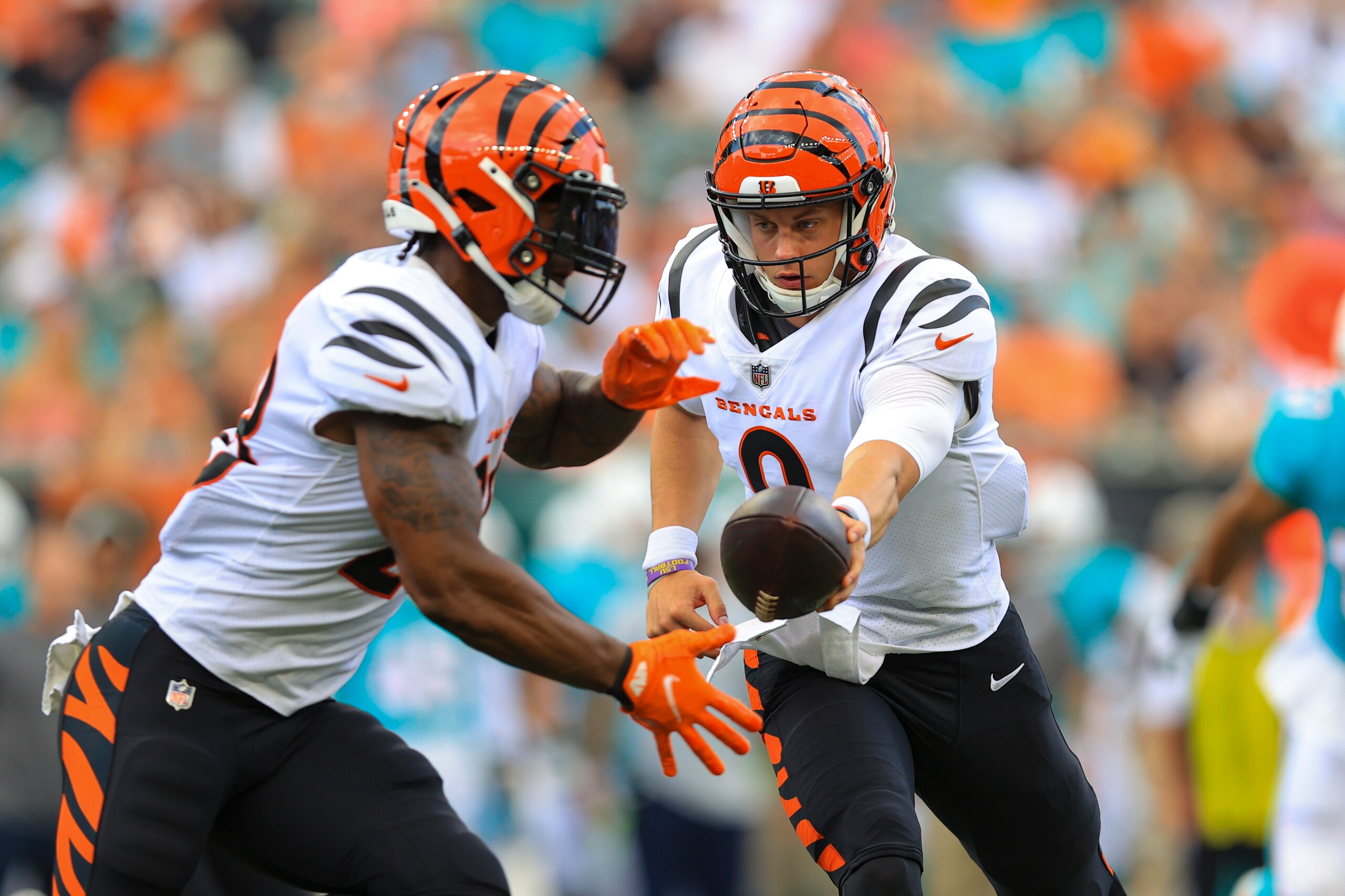 Cincinnati Bengals quarterback Joe Burrow (9) hands off to running back Joe Mixon (28) during the first half of an NFL exhibition football game in Cincinnati, Sunday, Aug. 29, 2021. (AP Photo/Aaron Doster)