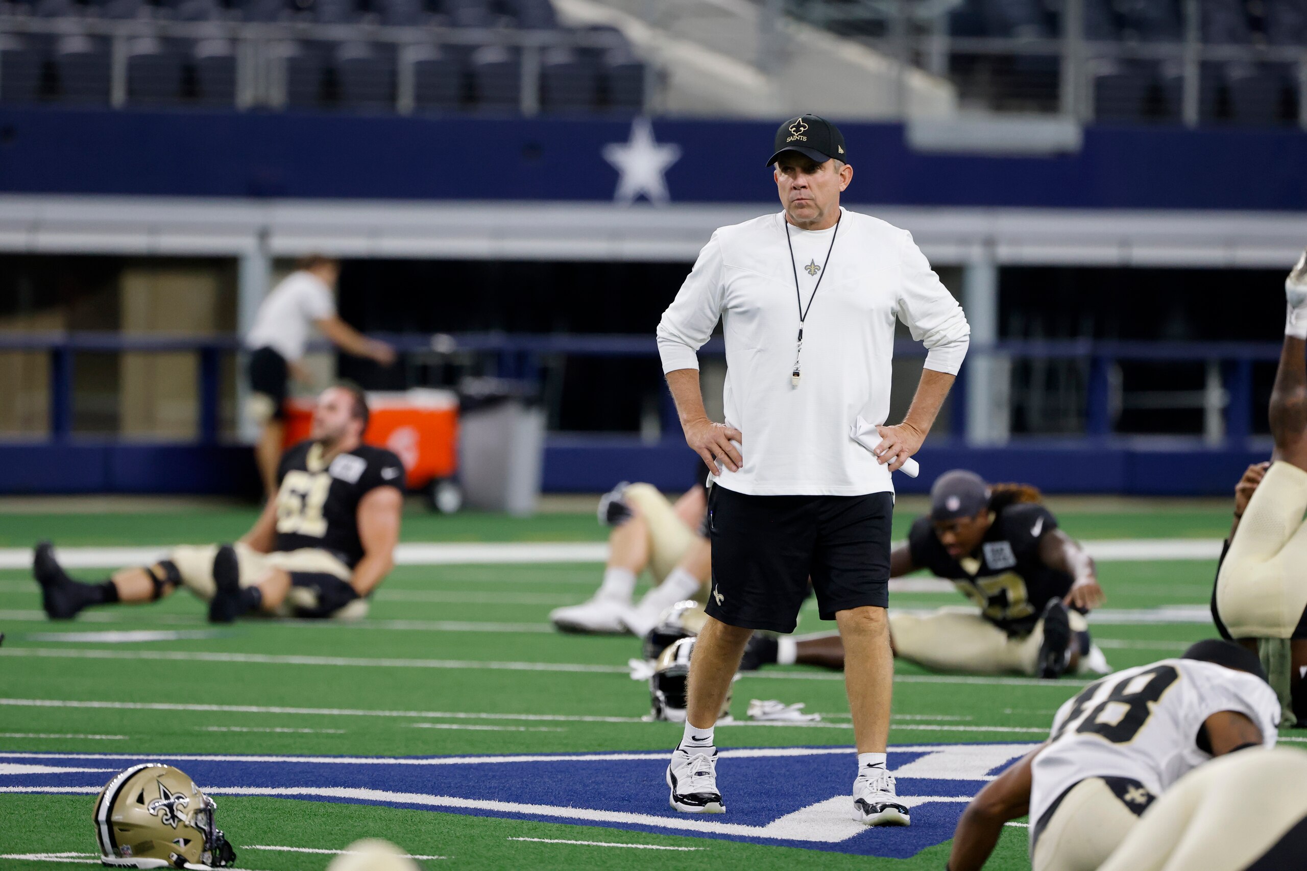 New Orleans Saints coach Sean Payton watches the team stretch as they prepare for an NFL football workout in Arlington, Texas, Monday, Aug. 30, 2021. Displaced by Hurricane Ida, the Saints went back to work Monday about 500 miles away in the home of another NFL team. (AP Photo/Michael Ainsworth) New Orleans Saints coach Sean Payton watches the team stretch as they prepare for an NFL football workout in Arlington, Texas, Monday, Aug. 30, 2021. Displaced by Hurricane Ida, the Saints went back to work Monday about 500 miles away in the home of another NFL team. (AP Photo/Michael Ainsworth)