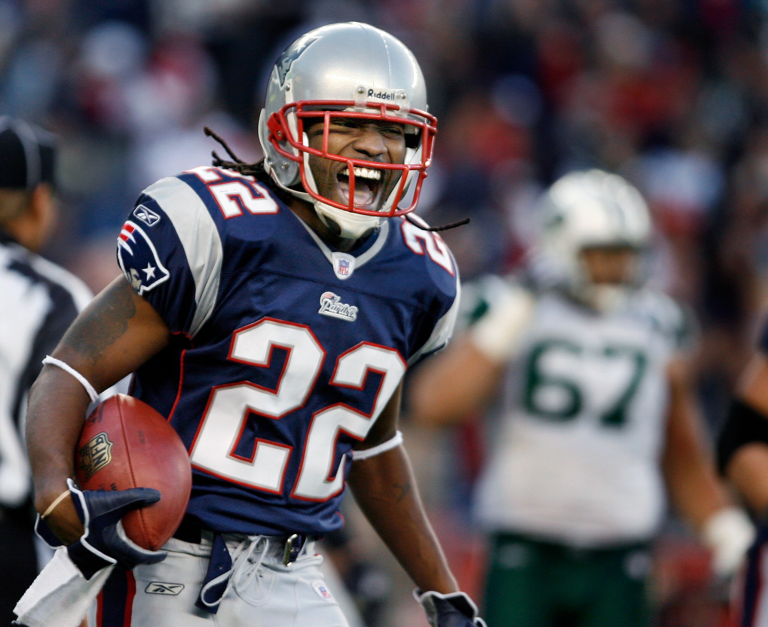 FOXBOROUGH, MA - JANUARY 7: Patriots cornerback Asante Samuel (22, left) has the ball, as well as a huge smile following his fourth quarter interception return for a touchdown that sealed New England's 37-16 victory. The New England Patriots face the New York Jets in a Wild Card playoff game at Gillette Stadium in Foxborough, MA on Jan. 7, 2007. (Photo by Jim Davis/The Boston Globe via Getty Images)