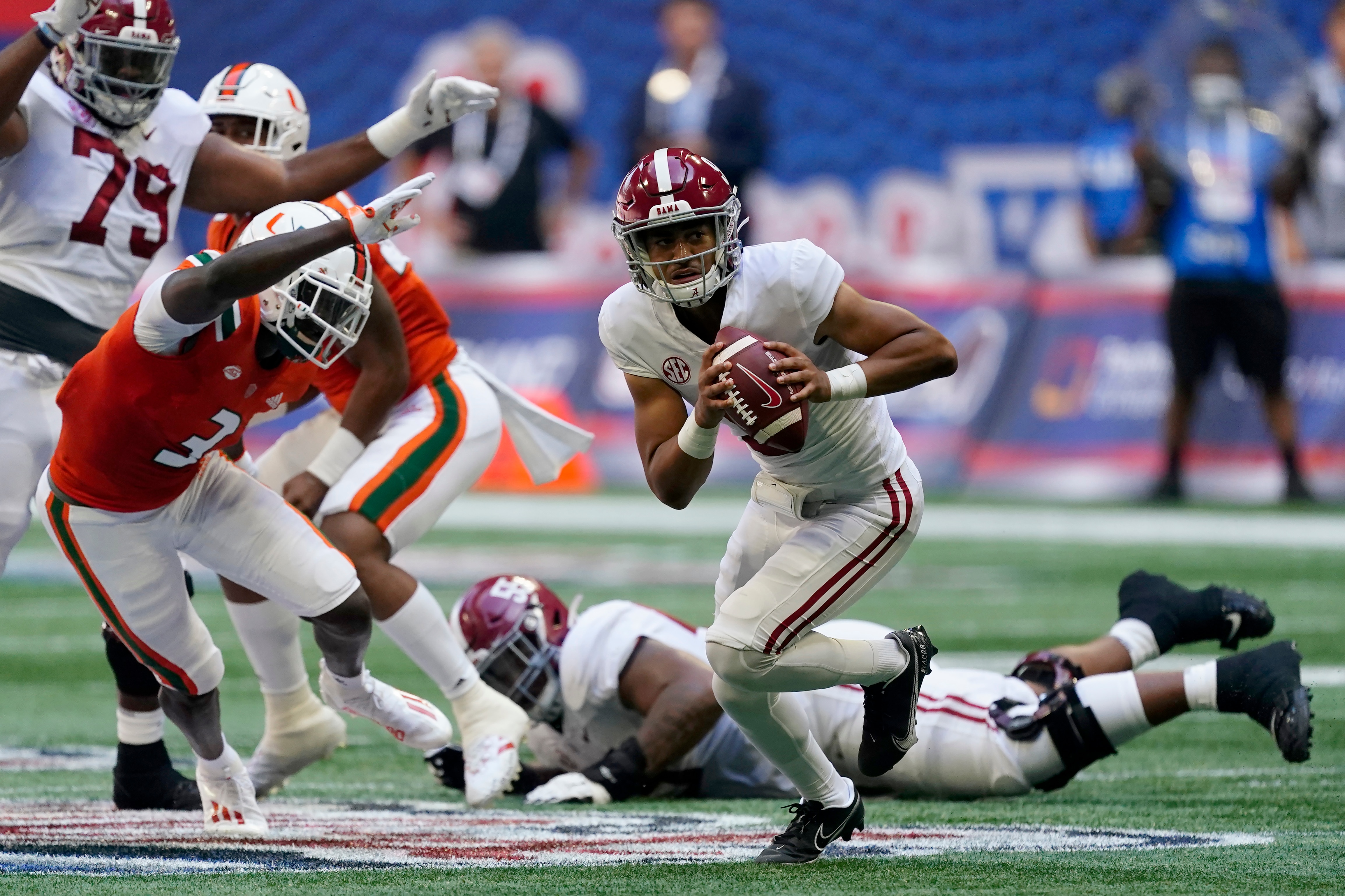 Alabama quarterback Bryce Young (9) scrambles away from Miami safety Gilbert Frierson (3) before throwing a touchdown pass during the first half of an NCAA college football game Saturday, Sept. 4, 2021, in Atlanta. (AP Photo/John Bazemore)