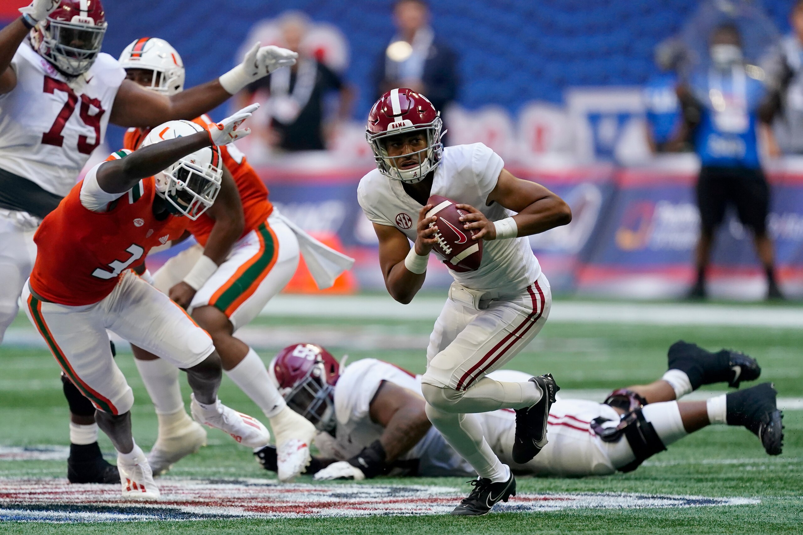 Alabama quarterback Bryce Young (9) scrambles away from Miami safety Gilbert Frierson (3) before throwing a touchdown pass during the first half of an NCAA college football game Saturday, Sept. 4, 2021, in Atlanta. (AP Photo/John Bazemore)