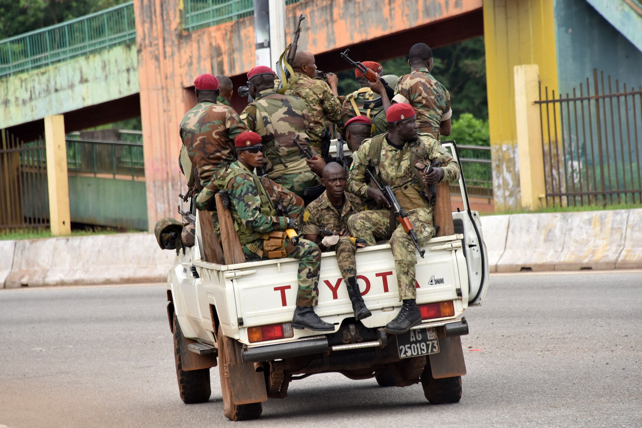 TOPSHOT - Members of the Armed Forces of Guinea drive through the central neighbourhood of Kaloum in Conakry on September 5, 2021 after sustainable gunfire was heard. - Gunfire was heard in Conkary in the morning and troops were seen on the streets, witnesses told AFP. There was no immediate explanation for the incidents in Conakry's Kaloum peninsula, where the presidency, various institutions and offices are located. (Photo by CELLOU BINANI / AFP) (Photo by CELLOU BINANI/AFP via Getty Images)
