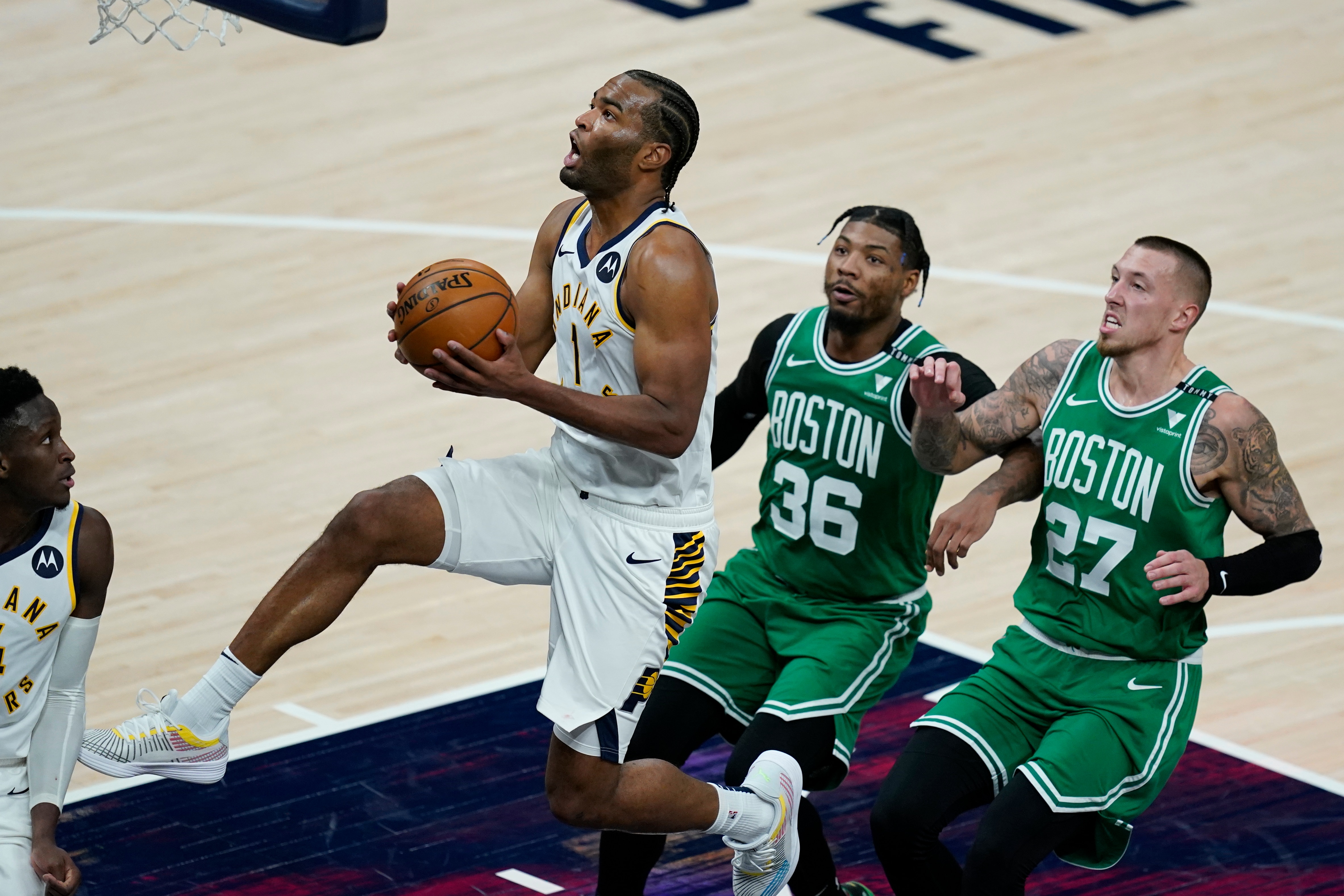 Indiana Pacers' T.J. Warren (1) goes to the basket as Boston Celtics' Marcus Smart (36) and Daniel Theis (27) trail during the second half of an NBA basketball game Tuesday, Dec. 29, 2020, in Indianapolis. (AP Photo/Darron Cummings)