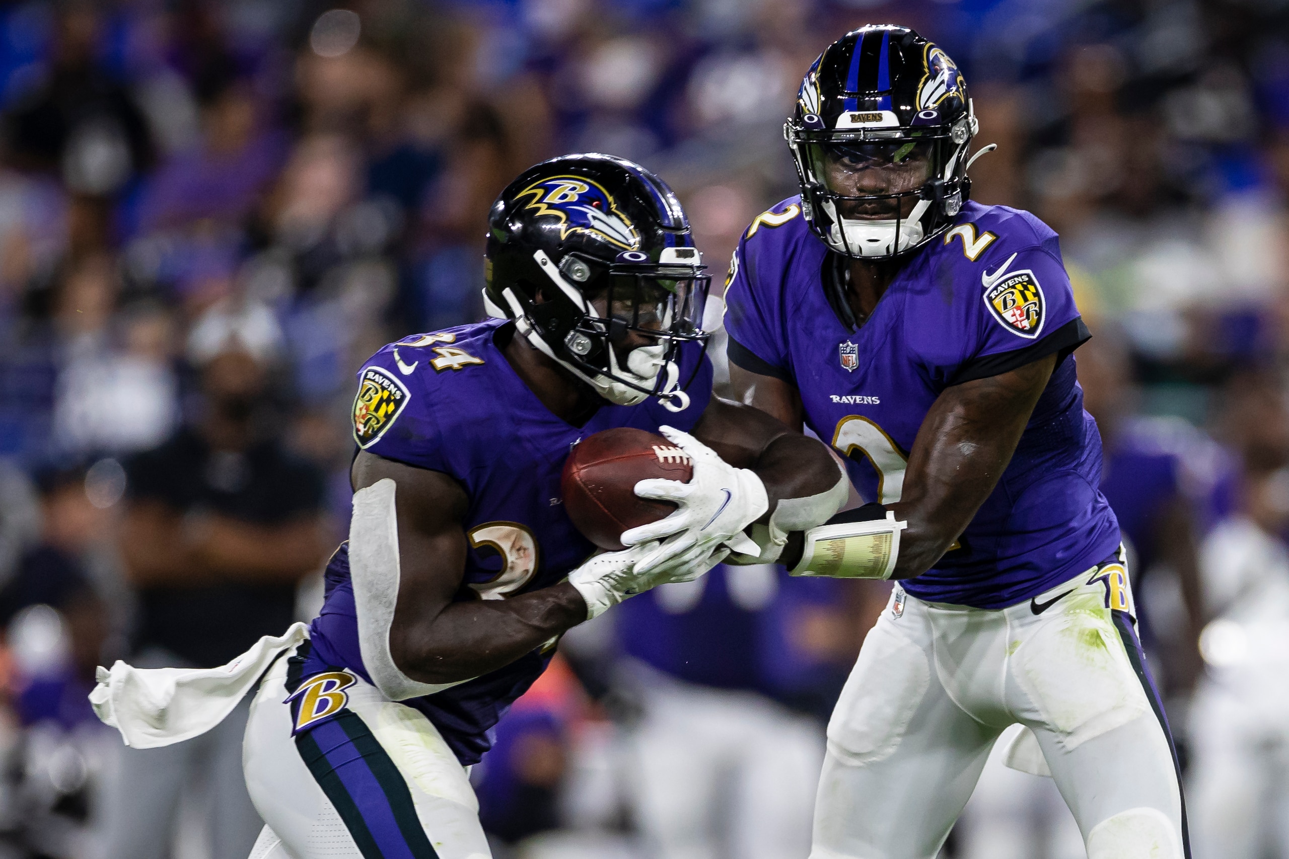 BALTIMORE, MD - AUGUST 14: Tyler Huntley #2 of the Baltimore Ravens hands the ball off to Ty'Son Williams #34 during the second half of a preseason game against the New Orleans Saints at M&T Bank Stadium on August 14, 2021 in Baltimore, Maryland. (Photo by Scott Taetsch/Getty Images)