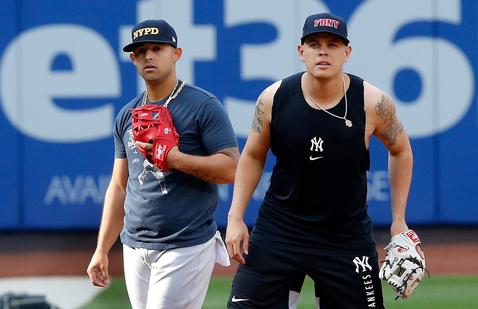NEW YORK, NEW YORK - SEPTEMBER 11:  Gio Urshela #29 (R) and Rougned Odor #12 of the New York Yankees warm up on the field wearing caps of the New York City Police and Fire Departments prior to a game against the New York Mets at Citi Field on September 11, 2021 in New York City. (Photo by Jim McIsaac/Getty Images)