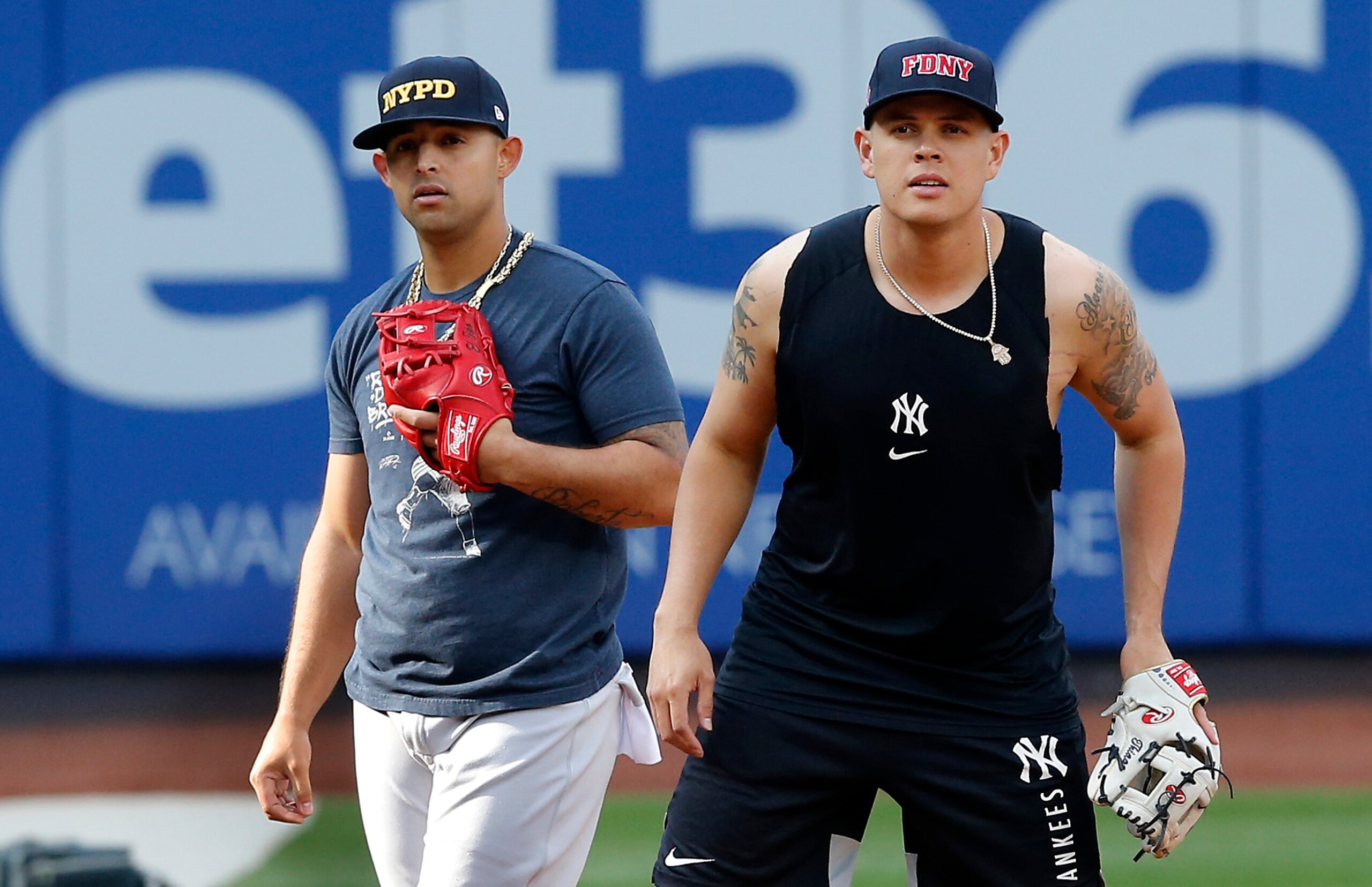 NEW YORK, NEW YORK - SEPTEMBER 11:  Gio Urshela #29 (R) and Rougned Odor #12 of the New York Yankees warm up on the field wearing caps of the New York City Police and Fire Departments prior to a game against the New York Mets at Citi Field on September 11, 2021 in New York City. (Photo by Jim McIsaac/Getty Images)