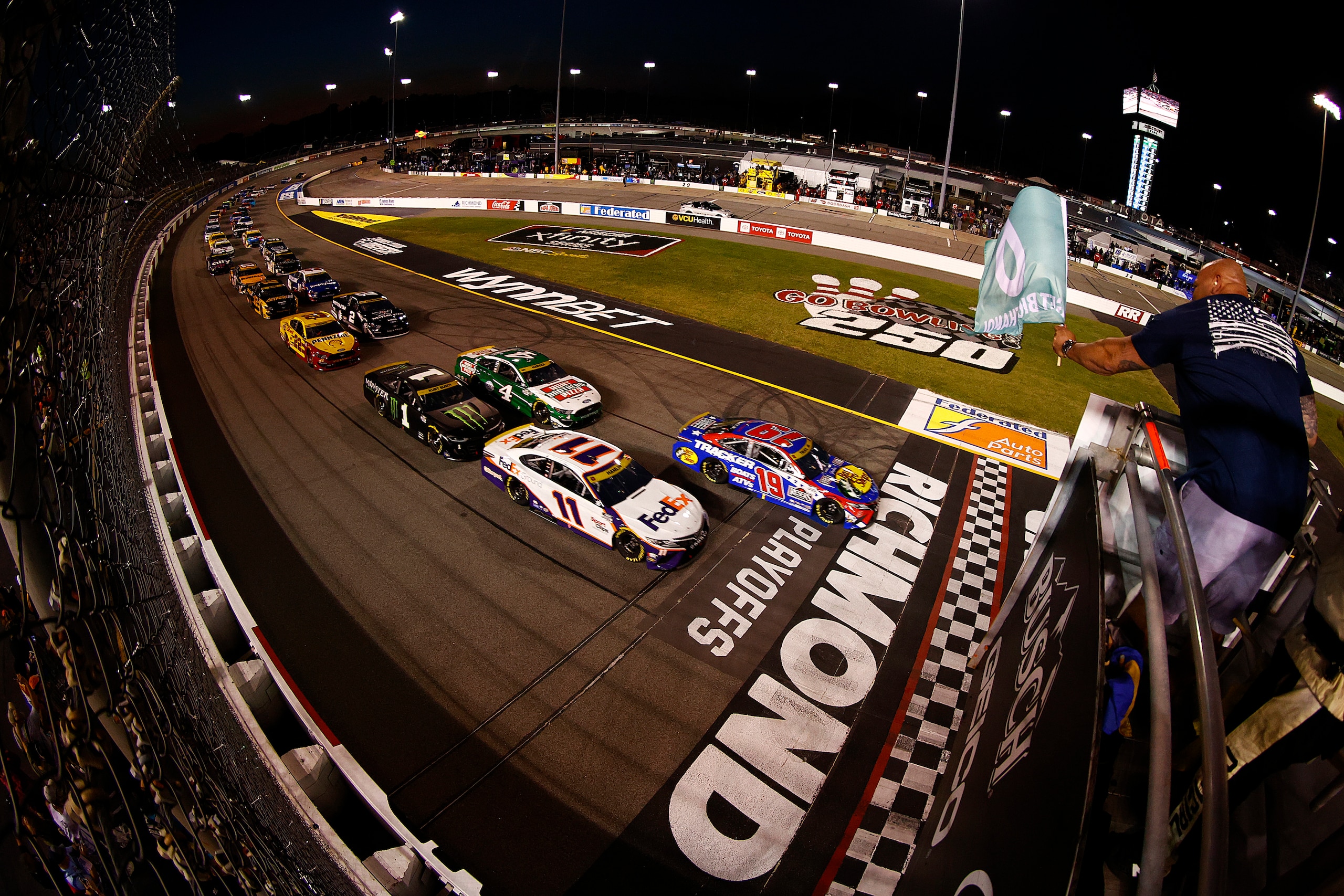 RICHMOND, VIRGINIA - SEPTEMBER 11:  Martin Truex Jr., driver of the #19 Bass Pro Shops Red White Blue Toyota, (penalized) and Denny Hamlin, driver of the #11 FedEx Ground Toyota, lead the field to the green flag the NASCAR Cup Series Federated Auto Parts 400 Salute to First Responders at Richmond Raceway on September 11, 2021 in Richmond, Virginia. (Photo by Jared C. Tilton/Getty Images)