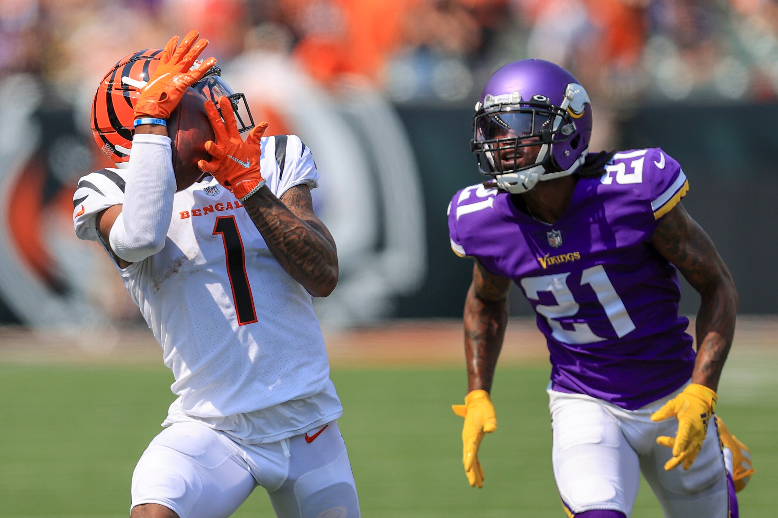Cincinnati Bengals wide receiver Ja'Marr Chase (1) makes a catch and takes it in for a touchdown past Minnesota Vikings defensive back Bashaud Breeland (21) in the first half of an NFL football game, Sunday, Sept. 12, 2021, in Cincinnati.(AP Photo/Aaron Doster)