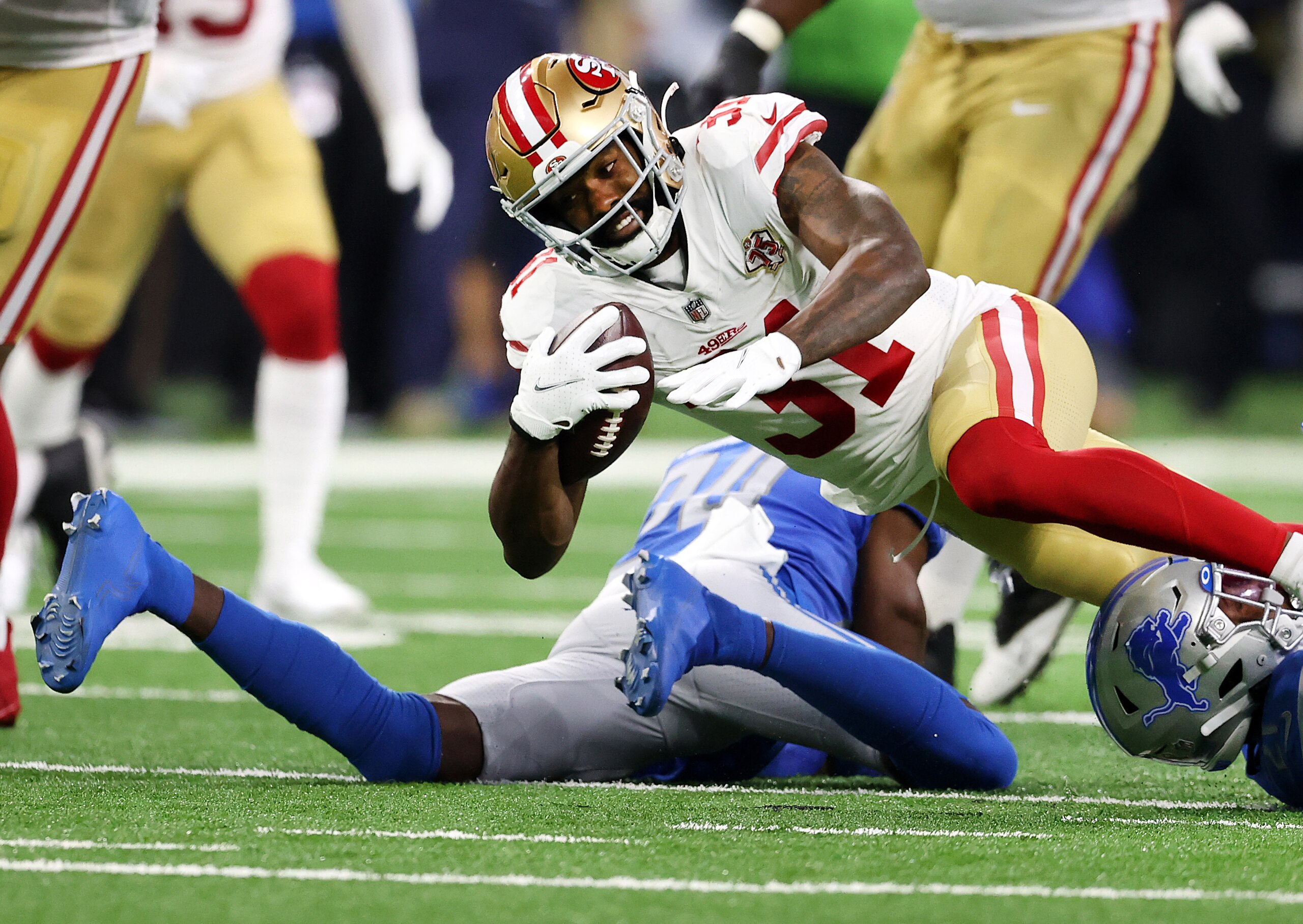 DETROIT, MICHIGAN - SEPTEMBER 12: Raheem Mostert #31 of the San Francisco 49ers is tackled during the first half against the Detroit Lions at Ford Field on September 12, 2021 in Detroit, Michigan. (Photo by Gregory Shamus/Getty Images)